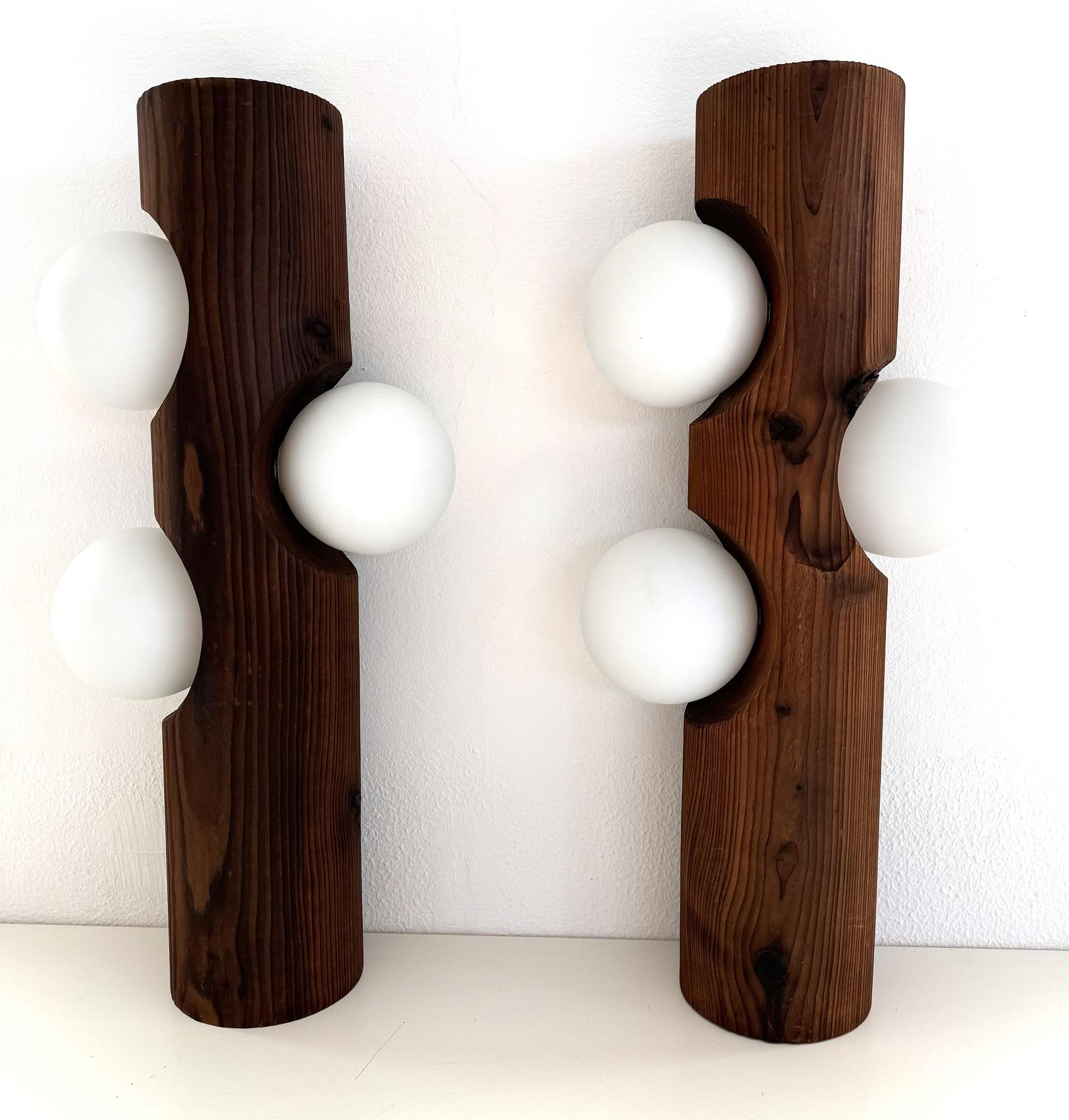 Inusuales y raros apliques orgánicos de gran tamaño, cada uno de ellos compuesto por un pesado tronco de árbol y tres globos de cristal blanco.
Los troncos son de pino macizo, con una hermosa pátina y un tacto agradable.
Los globos de cristal blanco