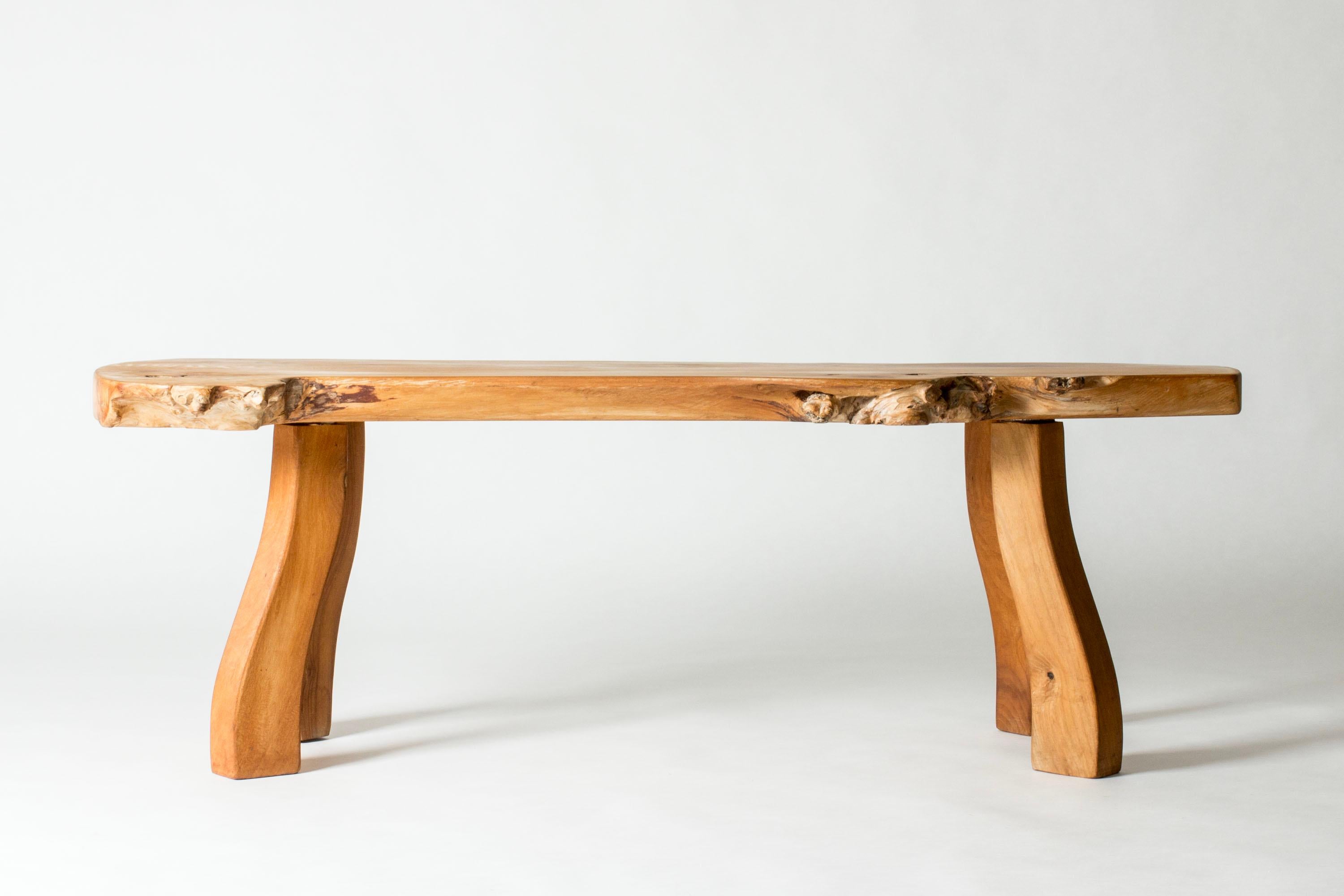 Ulmenholz-Couchtisch oder Konsolentisch von Carl-Axel Beijbom, hergestellt aus einer Ulmenholzplatte mit schönen Variationen im Holz. Schöne, geölte Oberfläche. Stabile, geformte Beine, die das organische Design der Tischplatte aufgreifen.

Die