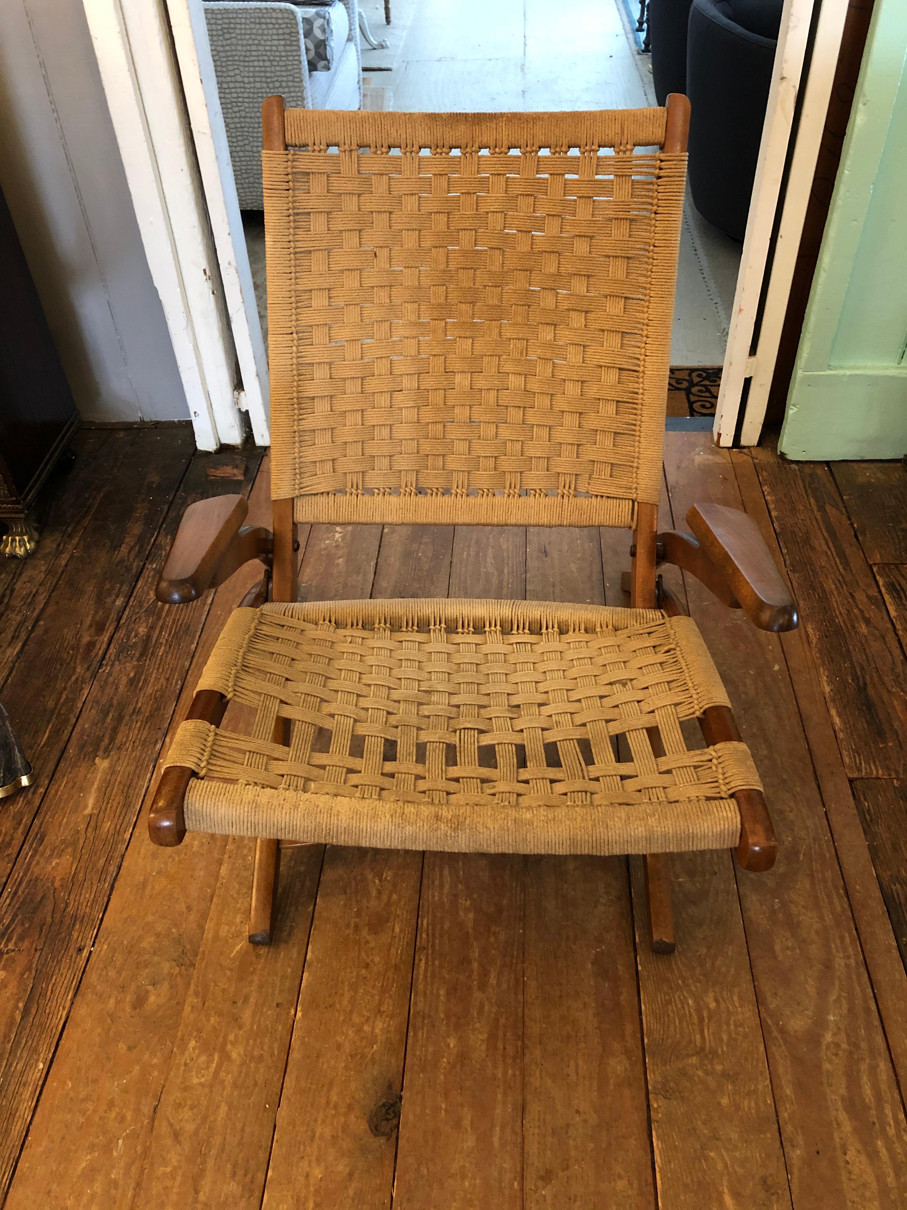 An ingeniously designed Mid-Century Modern woven rope chair having a low slung silhouette, handsome sleek wood arms and folding legs. Very comfortable and obviously portable.