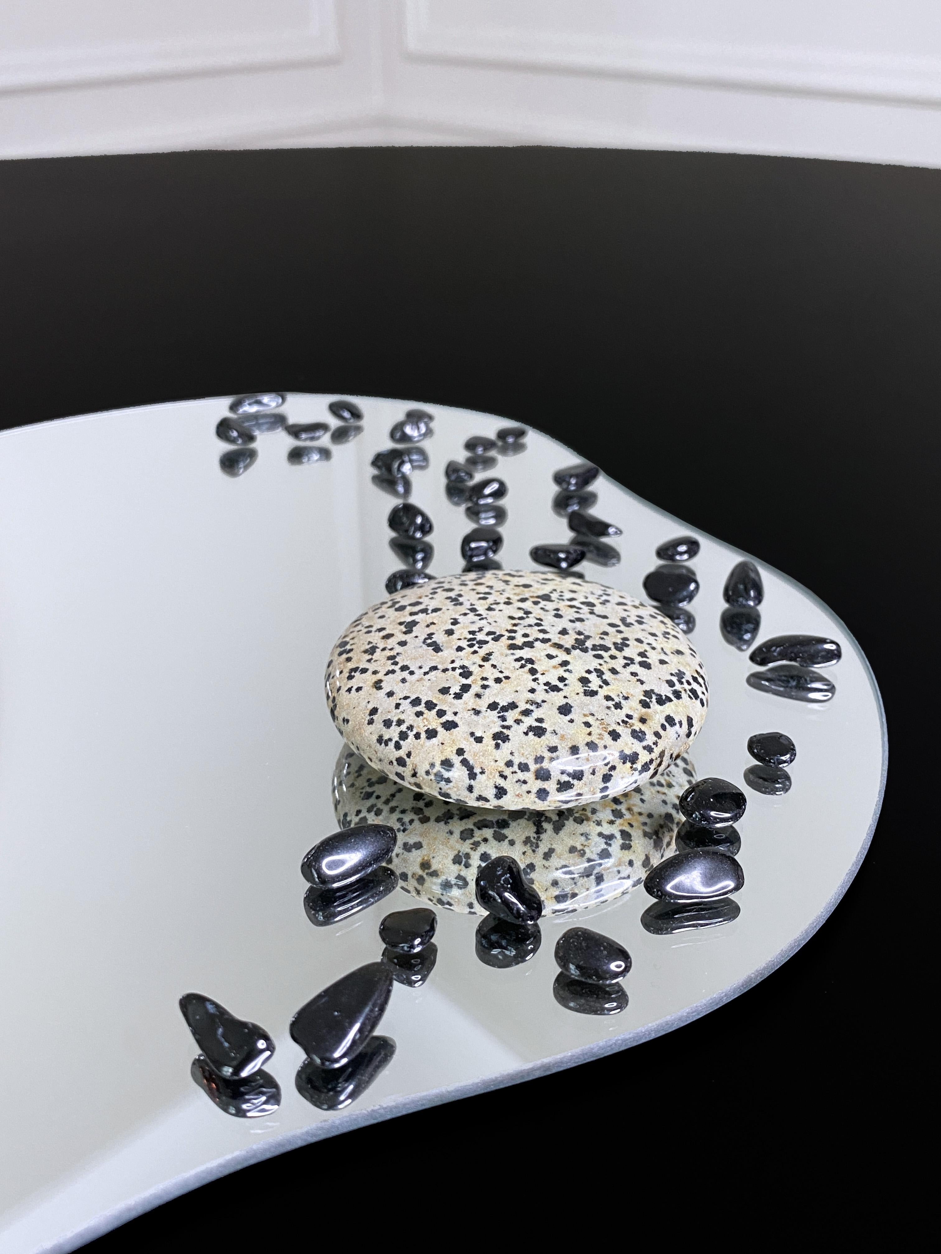 Plateau organique en miroir orné de jaspe dalmatien et d'onyx noir
Nombre de pierres : 1 jaspe de Dalmatie, 30 onyx noirs
Edition limitée, numérotée et signée

Chaque miroir est unique, tout comme les personnes qui le posséderont. Ils se distinguent