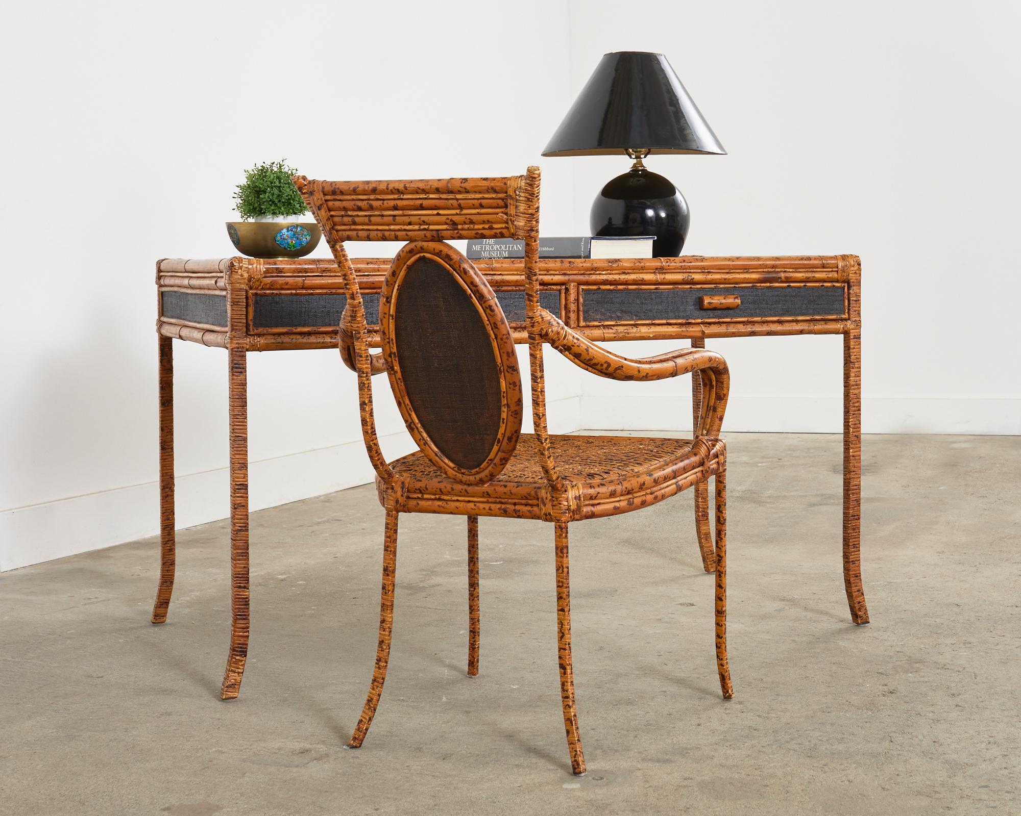 Wonderful organic modern writing table or desk featuring a strong iron frame wrapped with gorgeous tortoise shell bamboo and rattan. The top of the desk and sides have a lovely grasscloth inset finished in black lacquer. Fronted by two storage