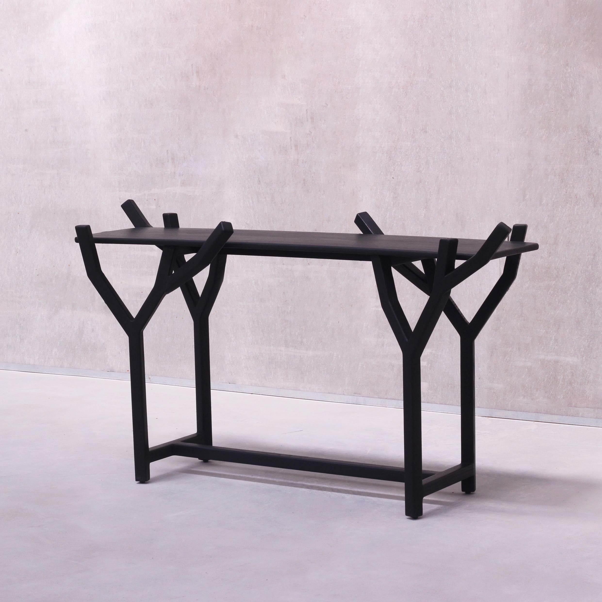 TOTEM is a sculptural and organic statement console table in Solid Oak wood, created inspired by the exemplary beauty and winding ascents of trees in nature, with an uncomplicated minimal aesthetic. The console table holds a complex construction in