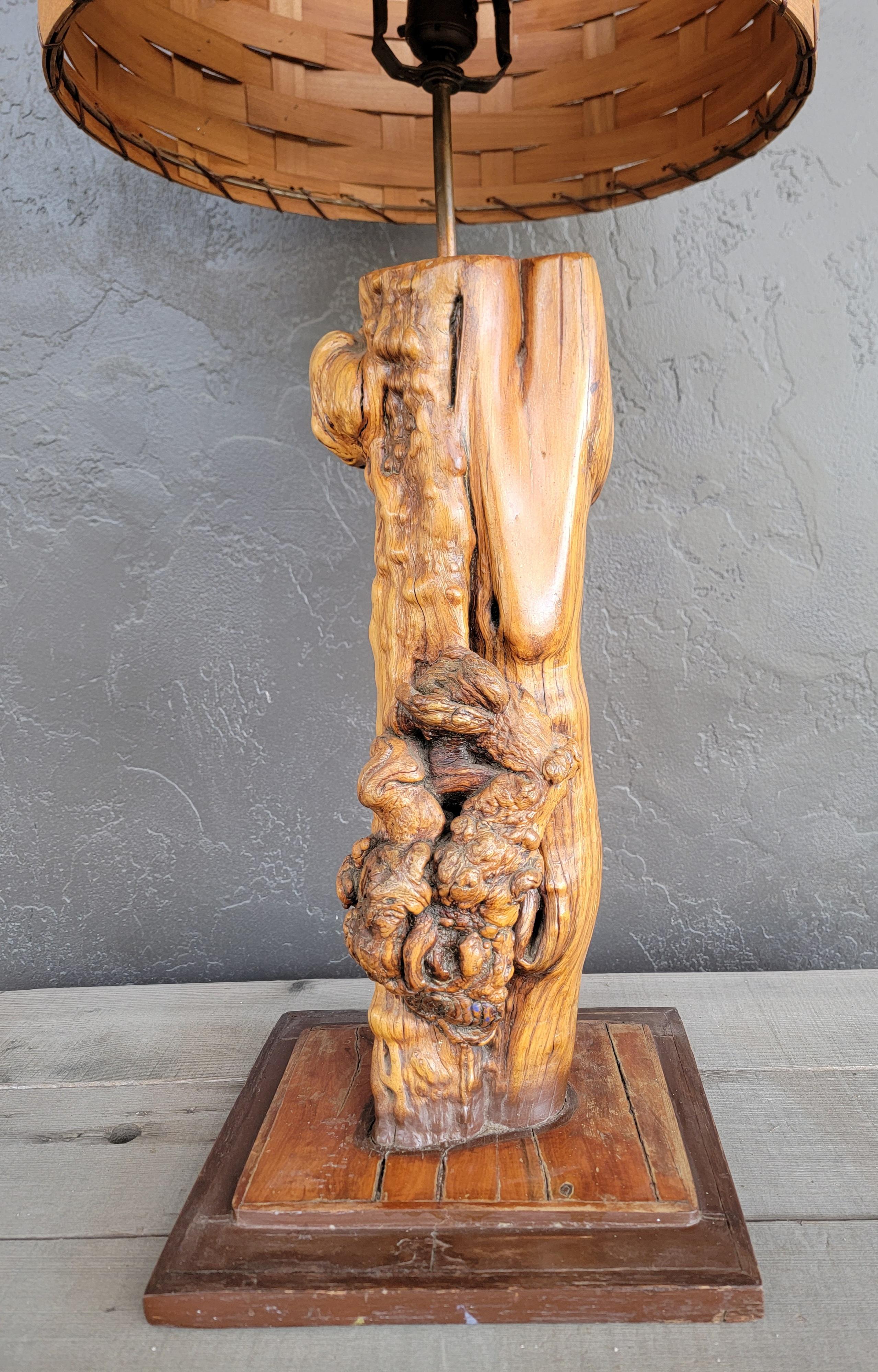 Lampe de table Organic Modern de belle facture. Bois de ronce exotique avec base de style Folk Art. Abat-jour original en bois tressé. Circa. 1950's. Très bon état.

34 pouces de haut.
Diamètre de 15 pouce.

Base de 11 pouces de large.
10 pouces de