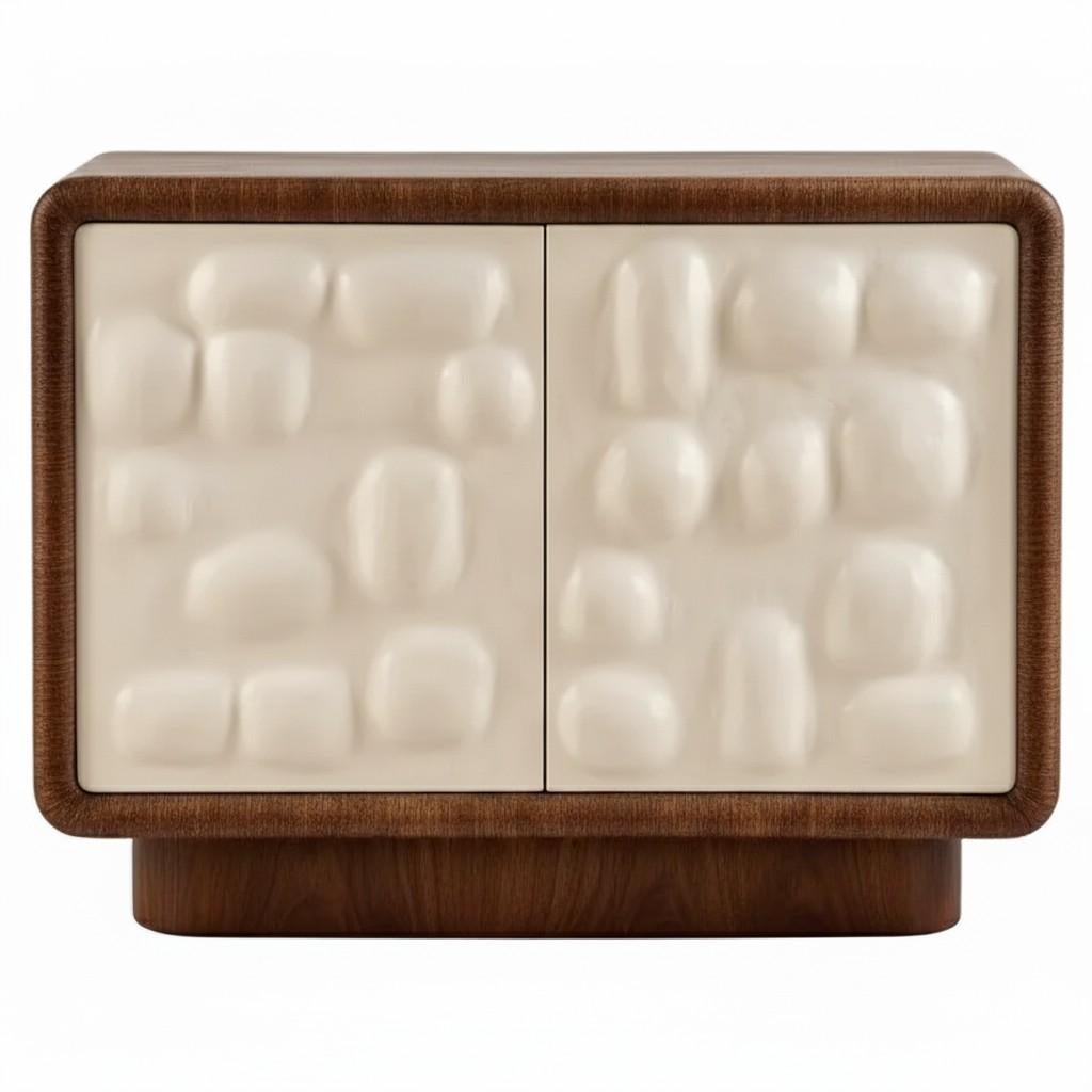 Cette élégante armoire à deux portes est fabriquée en bois de chêne et présente une finition cérusée sophistiquée qui met en valeur son grain naturel avec un bel effet chaulé. Les portes sont particulièrement caractéristiques, avec une texture