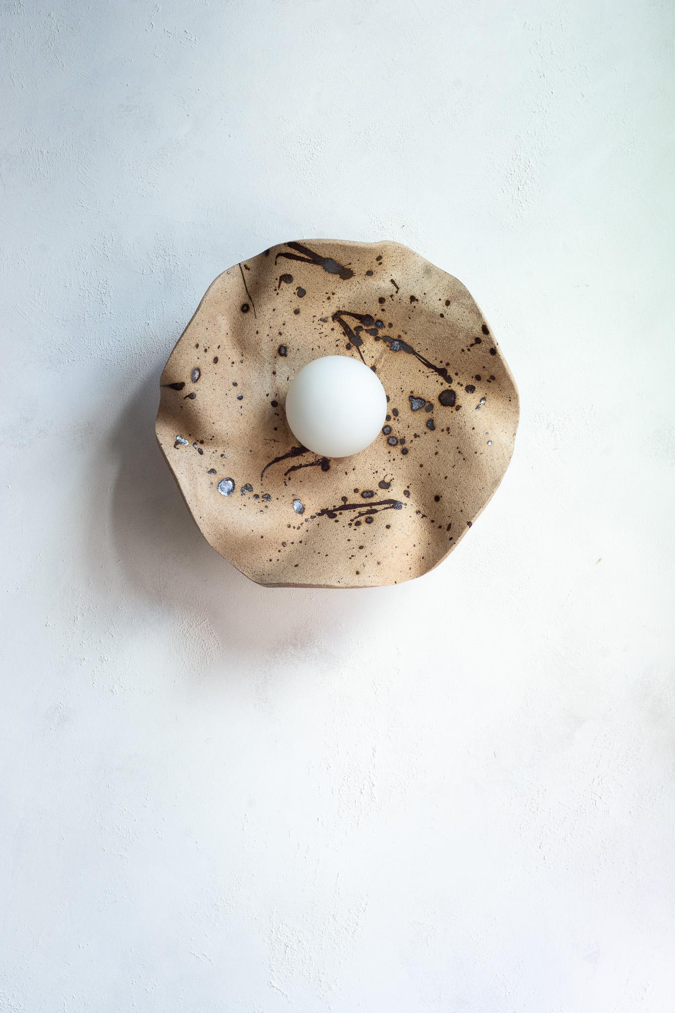 Funcional y escultural a la vez, este aplique de pared presenta un cautivador diseño orgánico y terroso. Se asemeja a una flor floreciente, pero también recuerda a las formaciones geológicas de las montañas.
Esculpida a mano a partir de múltiples