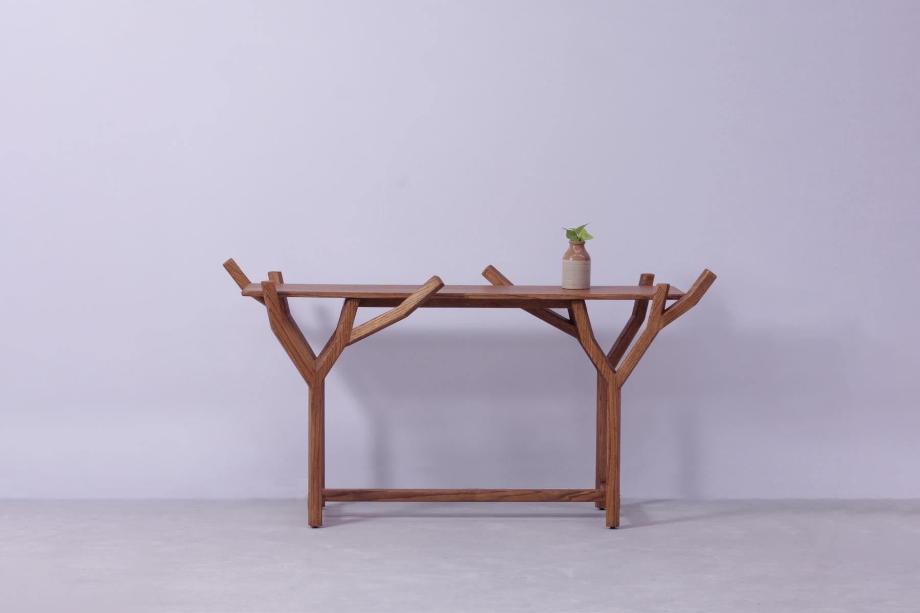 TOTEM is a sculptural and organic statement console table in Solid Oak wood, created inspired by the exemplary beauty and winding ascents of trees in nature, with an uncomplicated minimal aesthetic. The console table holds a complex construction in