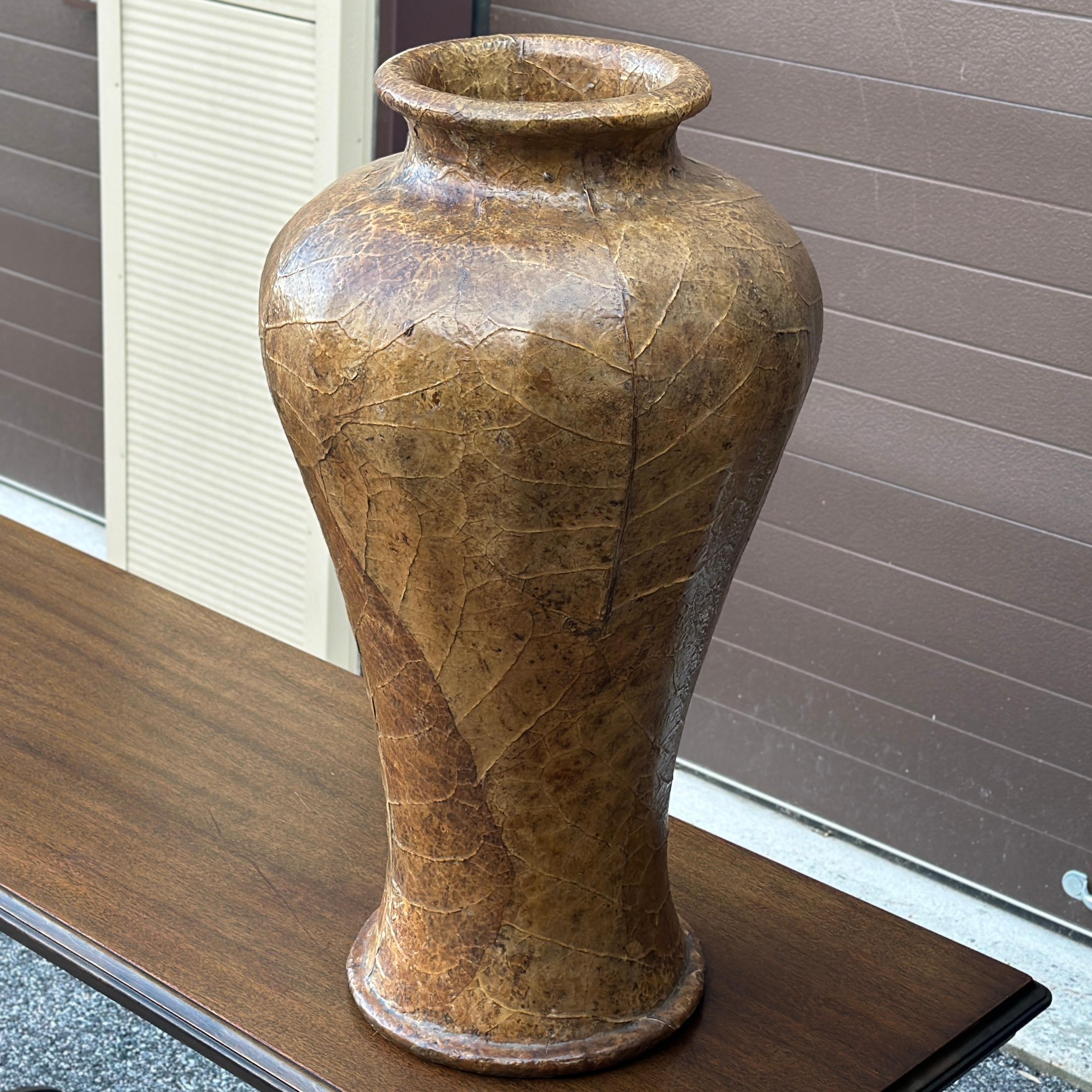 Vaso moderno organico a decoupage in foglie di tabacco o di banano di dimensioni eccessive
Realizzato in fibra di vetro o materiale simile, poi ricoperto di foglie naturali e rifinito. Apertura di circa 6
