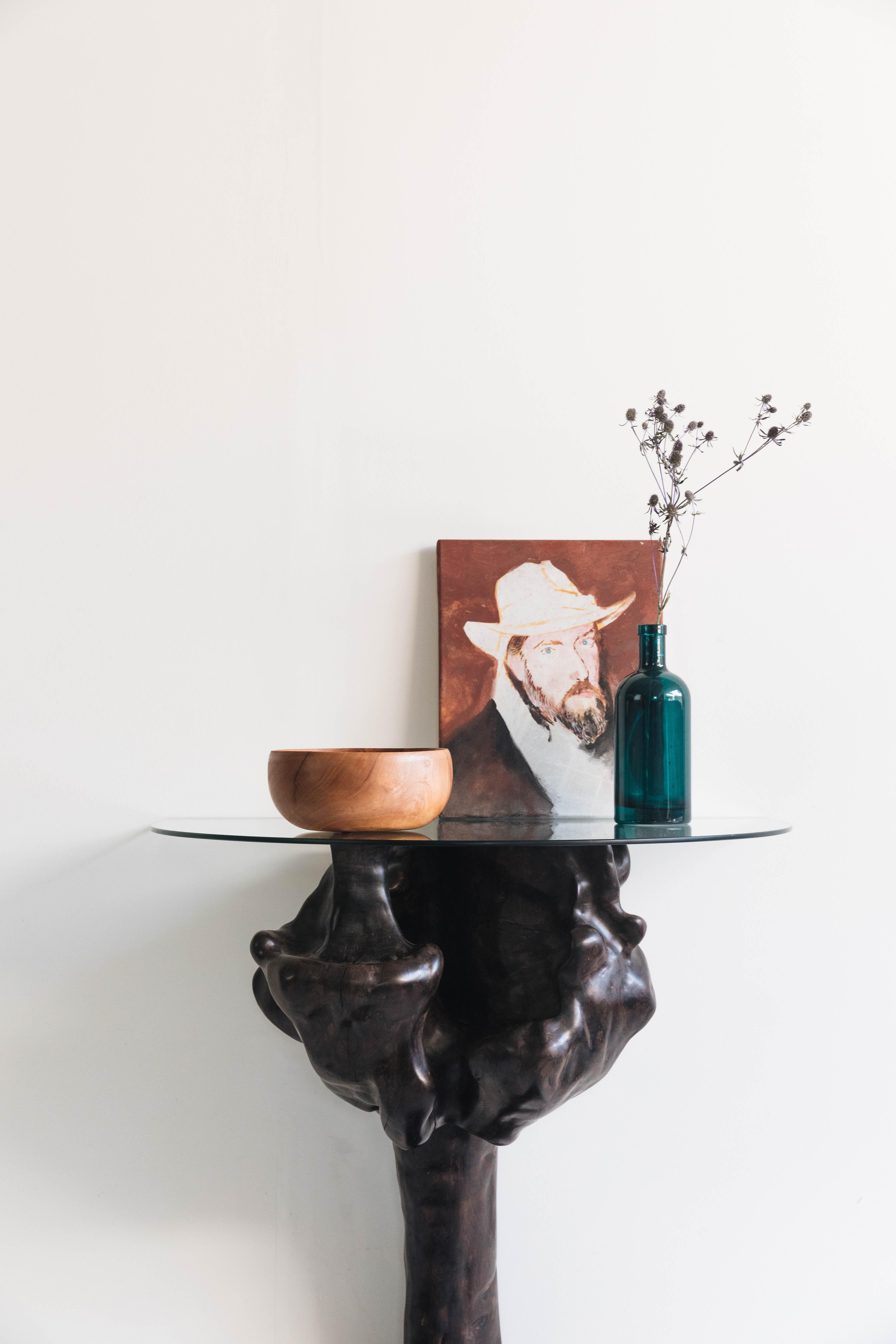 Introducing a one-of-a-kind entryway table, meticulously hand-carved from a stunning Ziricote burl. This remarkable piece showcases the natural beauty and intricate patterns of Ziricote wood, renowned for its dark, dramatic streaks and rich, exotic