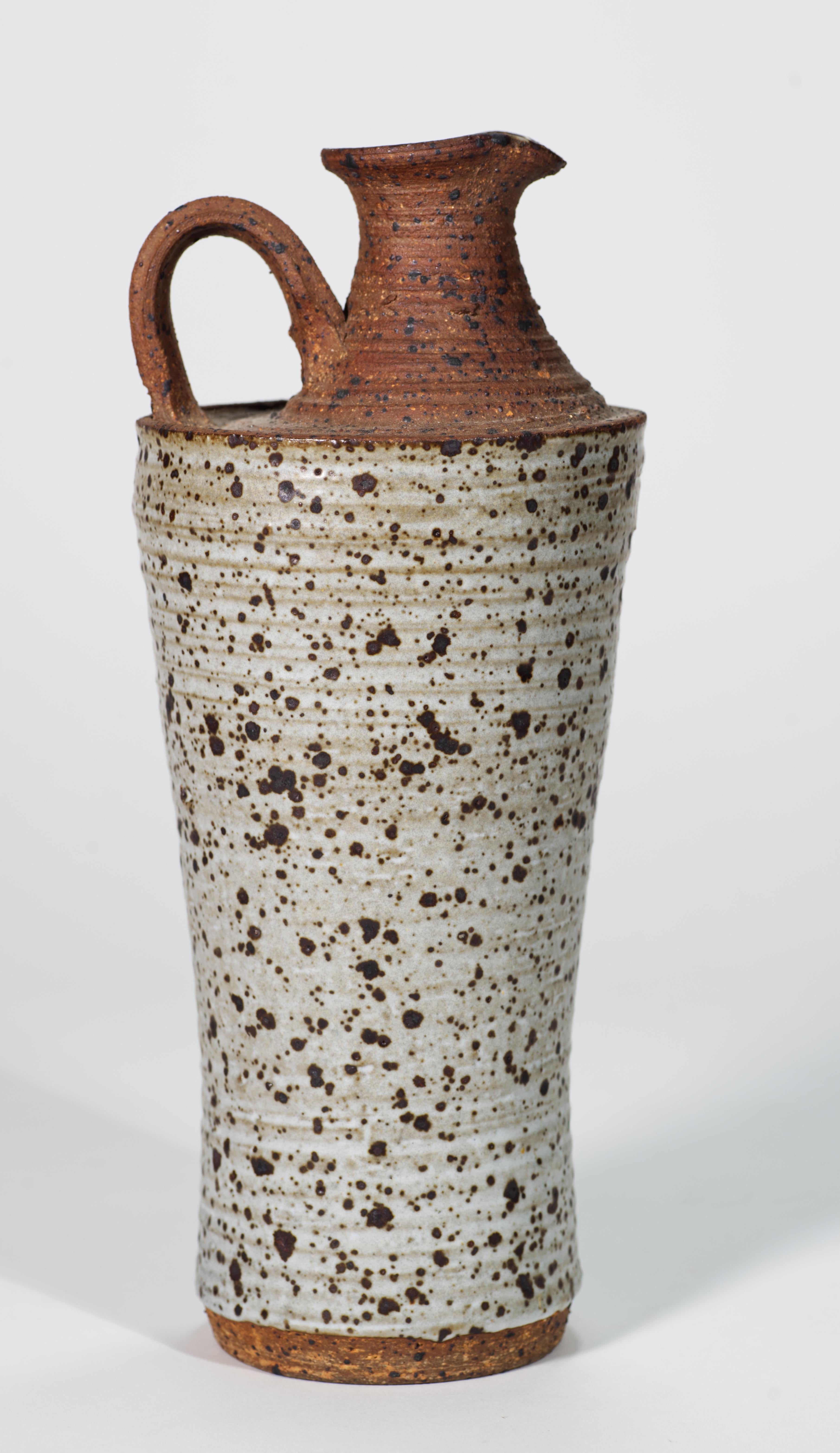  Il vaso in ceramica Organic Modern è caratterizzato da un corpo a forma di spiga, lavorato a mano, e da uno smalto salino grafico in una tavolozza di colori marrone e beige. La superficie leggermente strutturata del vaso è resa più evidente