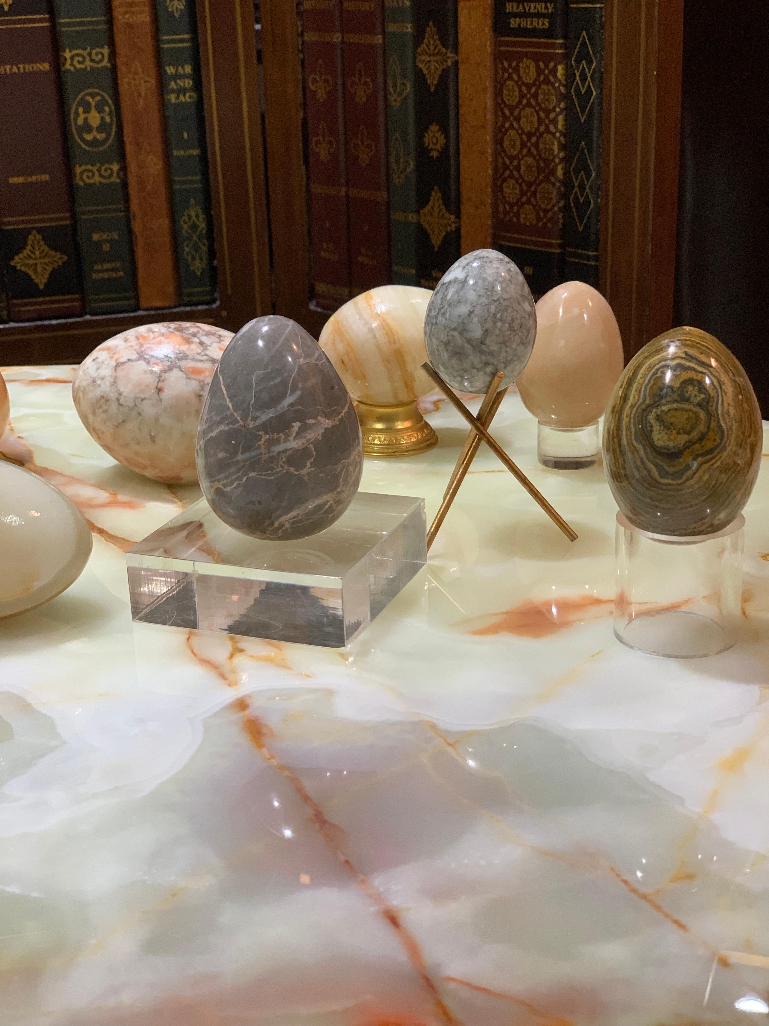 Organic modern hand carved stone egg sculptural set with brass and Lucite bases. Gorgeous three egg set, veined to perfection by Mother Nature and hand-burnished by midcentury artisans. 2 Lucite bases, 1 brass stand as well 3 stone eggs for 6 items