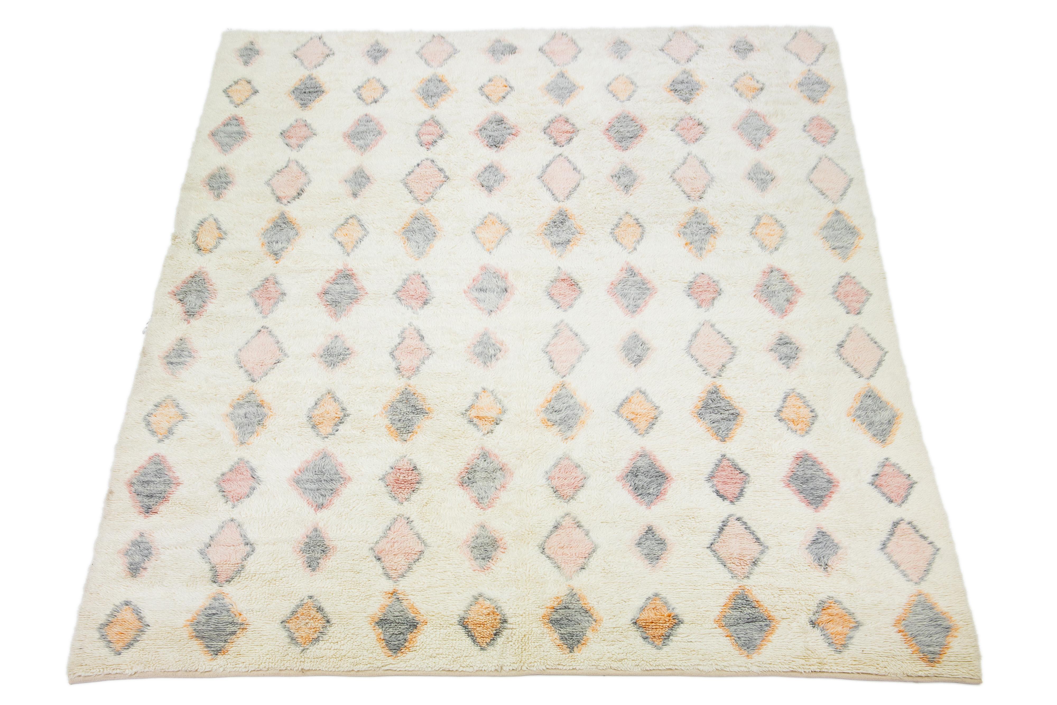The shaggy rug, hand-knotted and crafted from organic wool, embodies a stylish Moroccan design. It features a captivating ivory-toned background with multicolor accents.

This rug measures 11'2