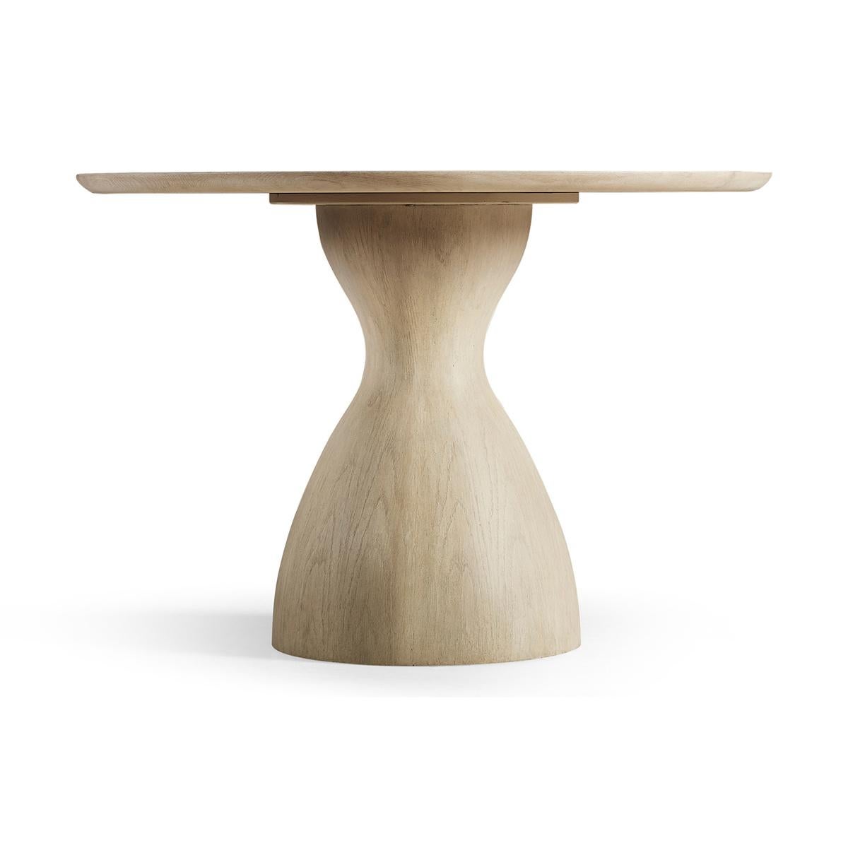 Organic Modern oak pedestal dining table. Unending symmetry, remarkable simplicity and true down-to-Earth balance come together in expertly crafted solid hardwoods and veneers finished in bleached oak. A wood top features a center cut out revealing