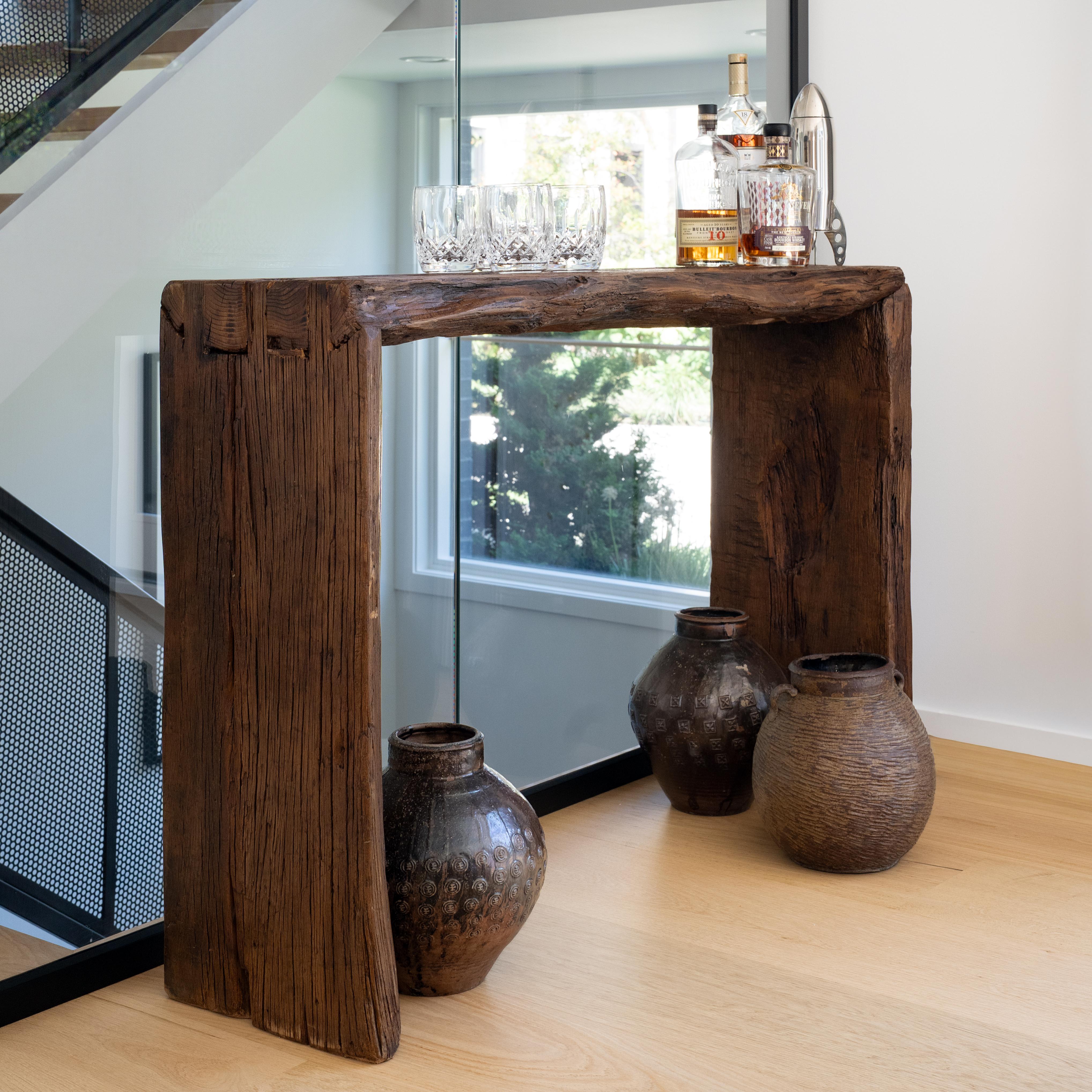 This contemporary console table is a celebration of wabi-sabi style. Crafted of wood reclaimed from Qing-dynasty architecture, the table has a minimalist waterfall design with dovetailed corners that recreate traditional joinery methods and add