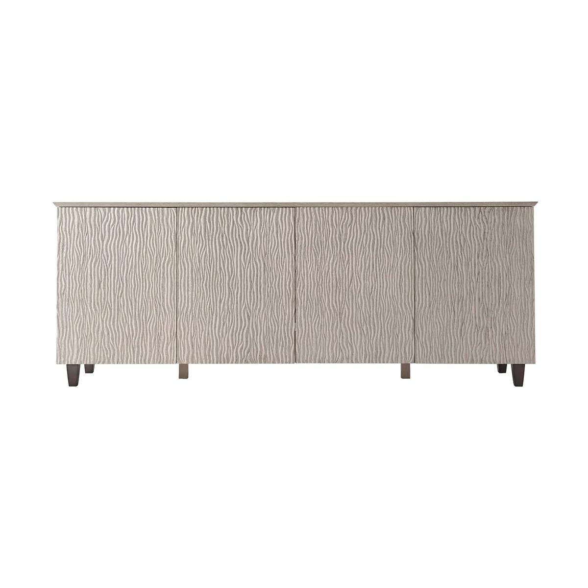 Organic modern Ripple oak sideboard with a rectangular knife edge top, brushed quarter oak veneers, with four ripple carved oak doors in our light Gowan finish raised on square tapered legs.

Dimensions: 80
