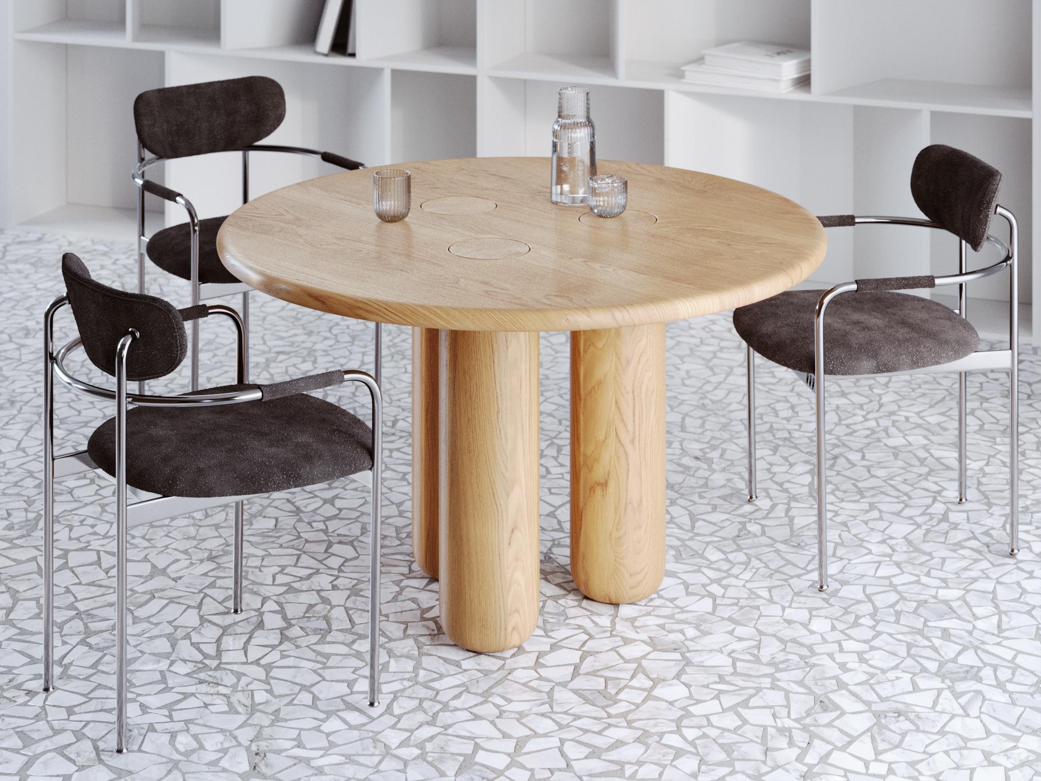 This dining table is crafted from solid oak in a natural finish, revealing the authentic warmth and expressive grain of the wood. Designed in an organic modern style, its flowing lines and natural geometry give the impression of a form shaped by