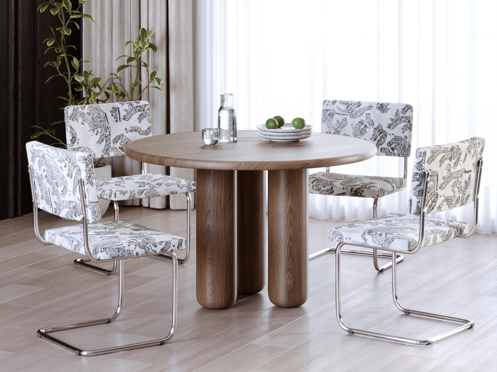 This contemporary dining table is crafted from solid walnut, showcasing the rich warm tones and distinctive natural grain of the wood. Inspired by biodesign, its organic form appears as if shaped by nature itself. The round tabletop with smooth
