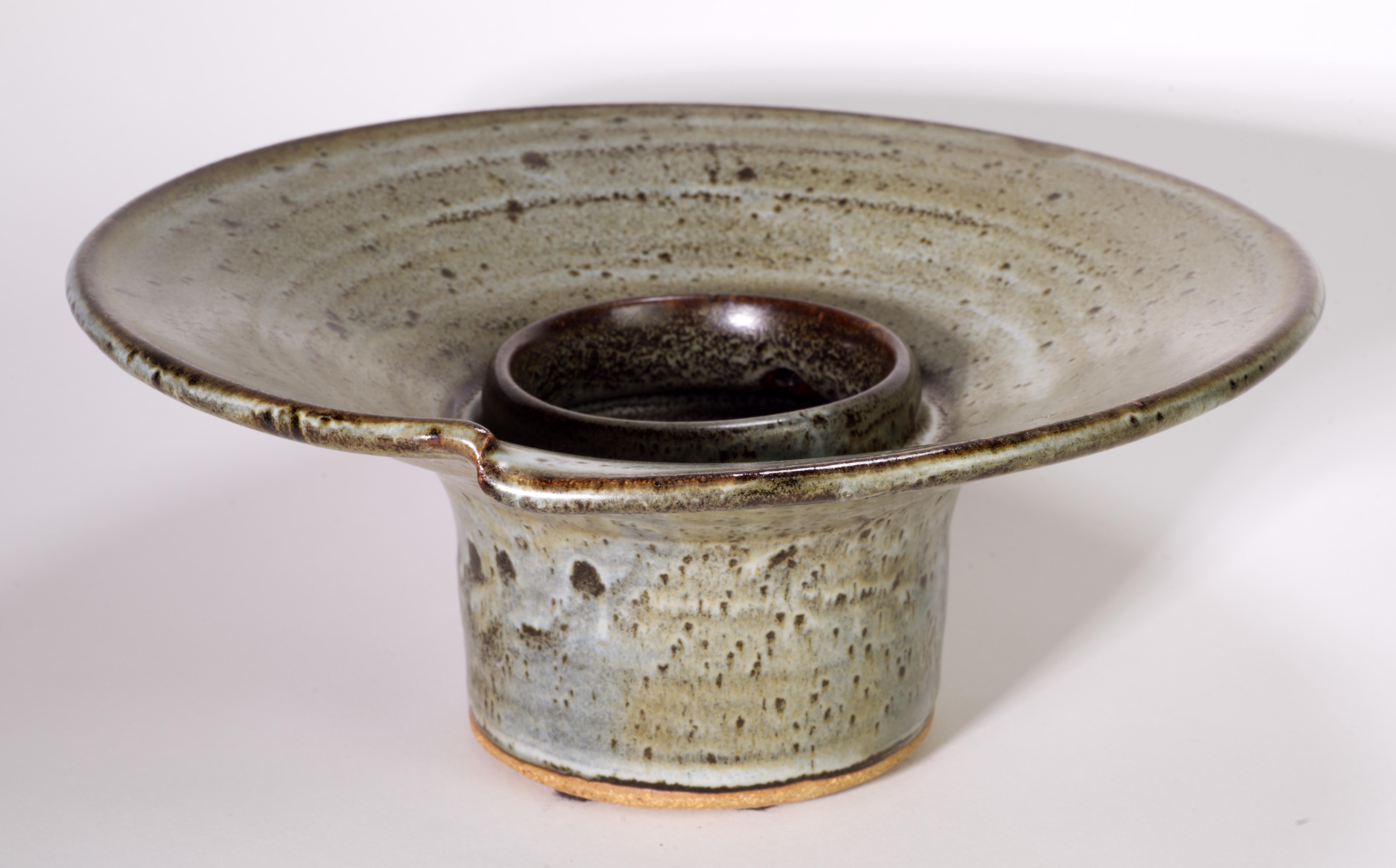  Il vaso moderno organico di Ikebana è stato realizzato a mano a forma di ciotola con i piedi. È decorato con smalti al sale nella tavolozza dei colori grigio e marrone. Il bordo è accentuato da un dettaglio asimmetrico che viene evidenziato da uno