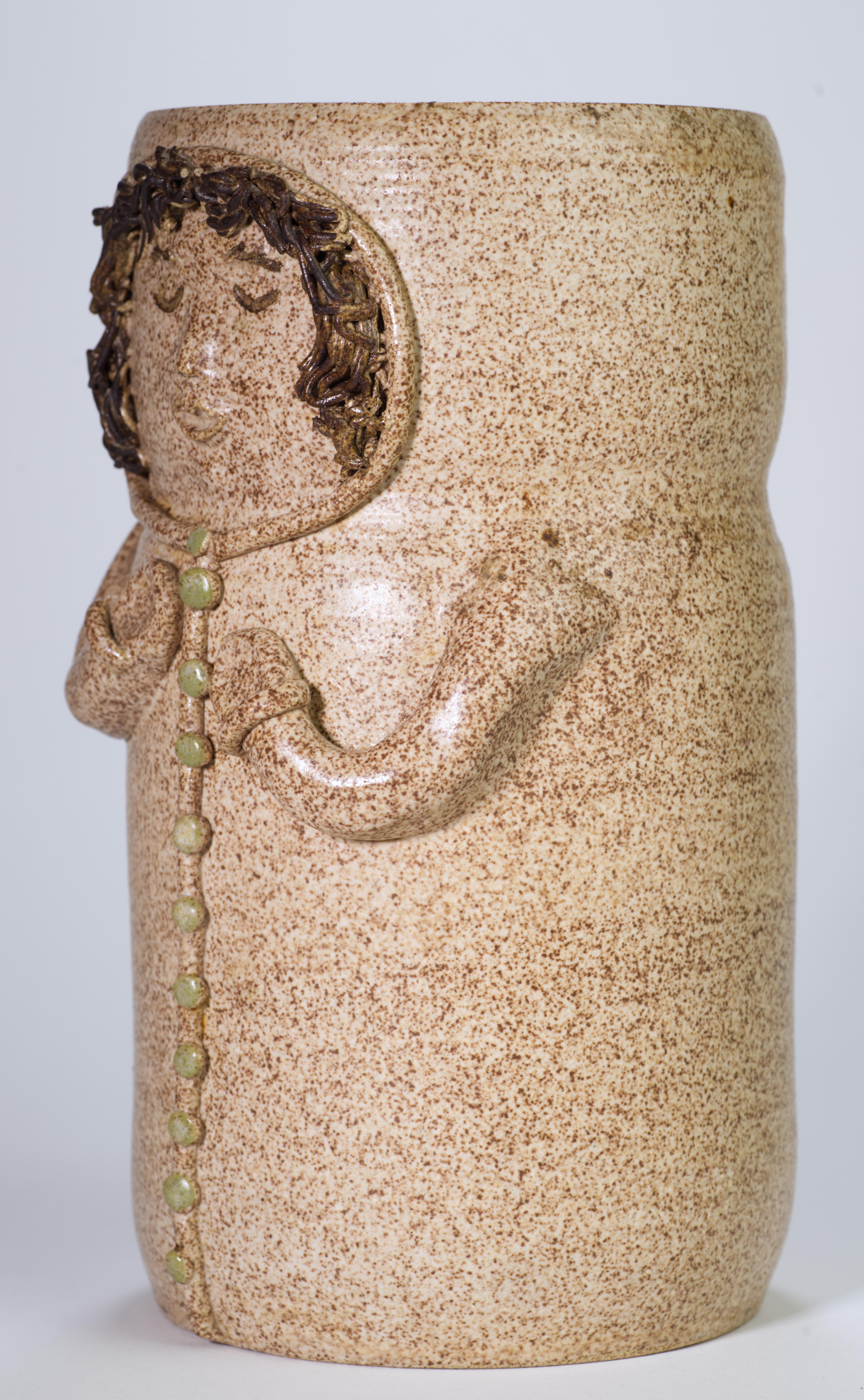  El jarrón de cerámica moderna orgánica fue lanzado a mano en forma de cilindro manipulado. Está decorada con el relieve de una figura de niña sobre fondo mate de esmalte salino marrón-beige. El relieve es de estilo abstracto, pero tiene detalles
