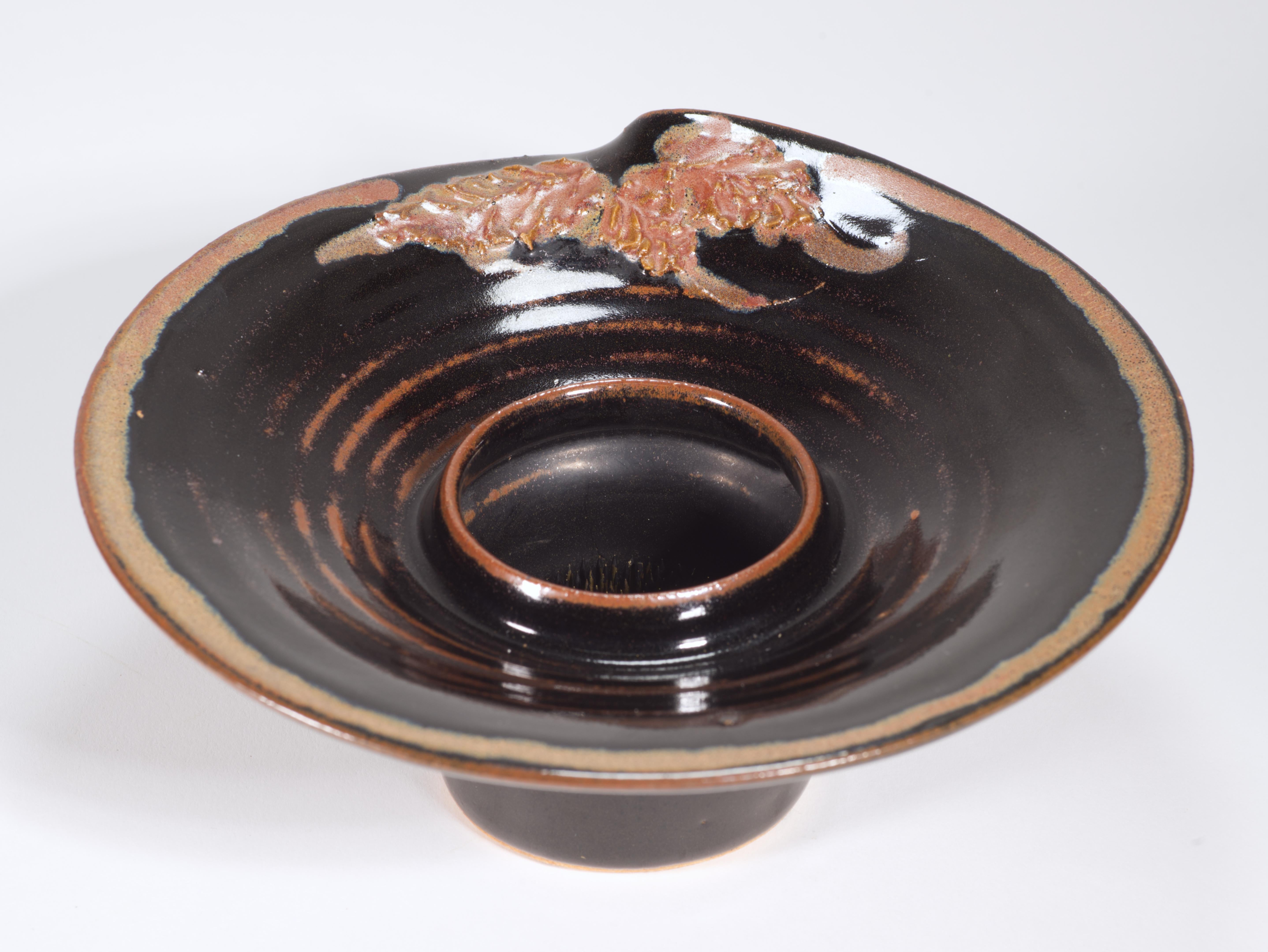  Organische moderne Ikebana-Vase wurde von Hand in Form einer Schale mit Fuß gedreht. Sie ist mit abstrakten, reliefartig geformten Blättern und konzentrischen Rändern in dunklem Espressobraun und Beigetönen verziert; die Glasur variiert von