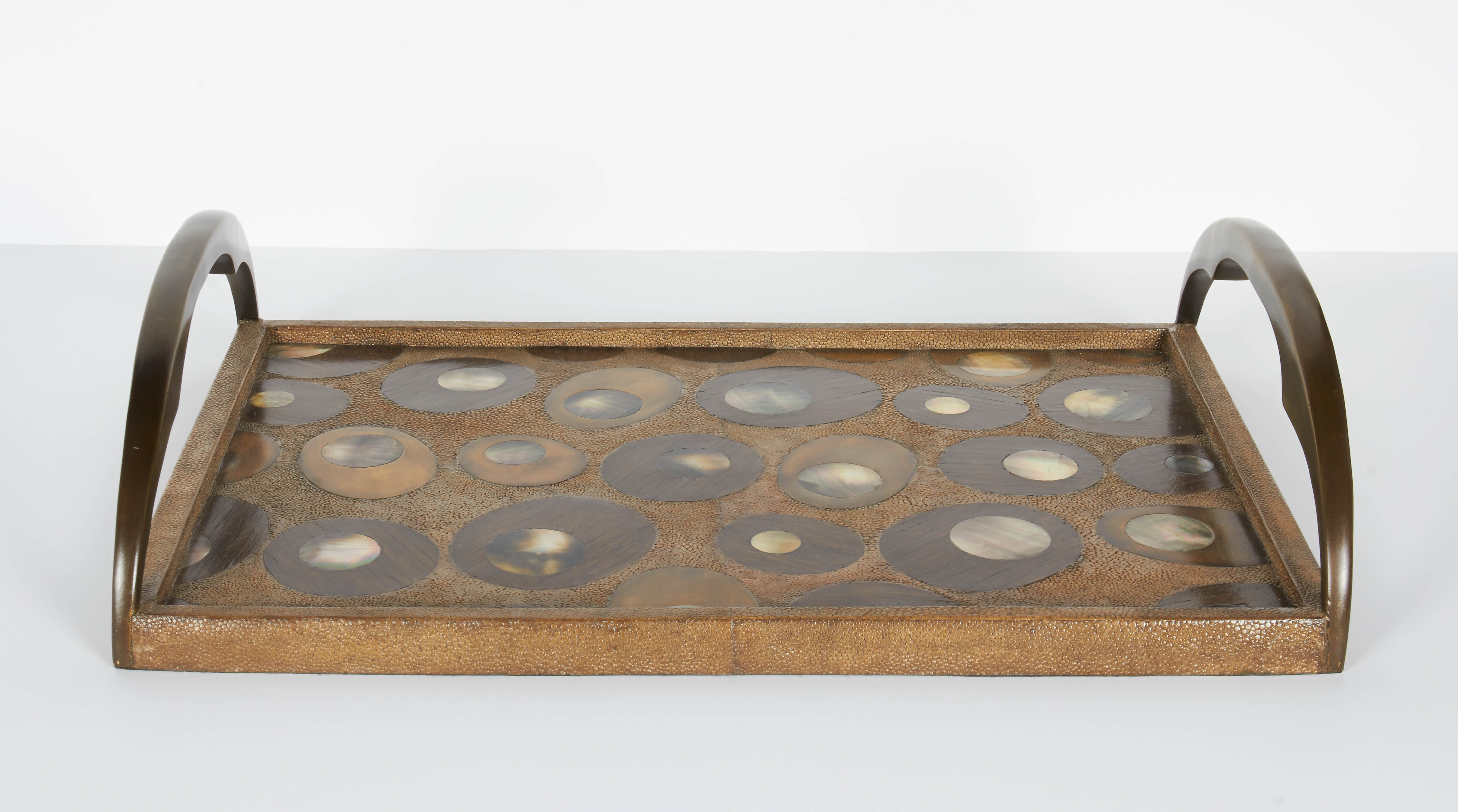 Exquisite serving tray features a variety of exotic materials and is all handcrafted. Covered in shagreen with hues of tan, and features mother of pearl inlays over palmwood insets. The combination creates a beautiful concentric and geometric