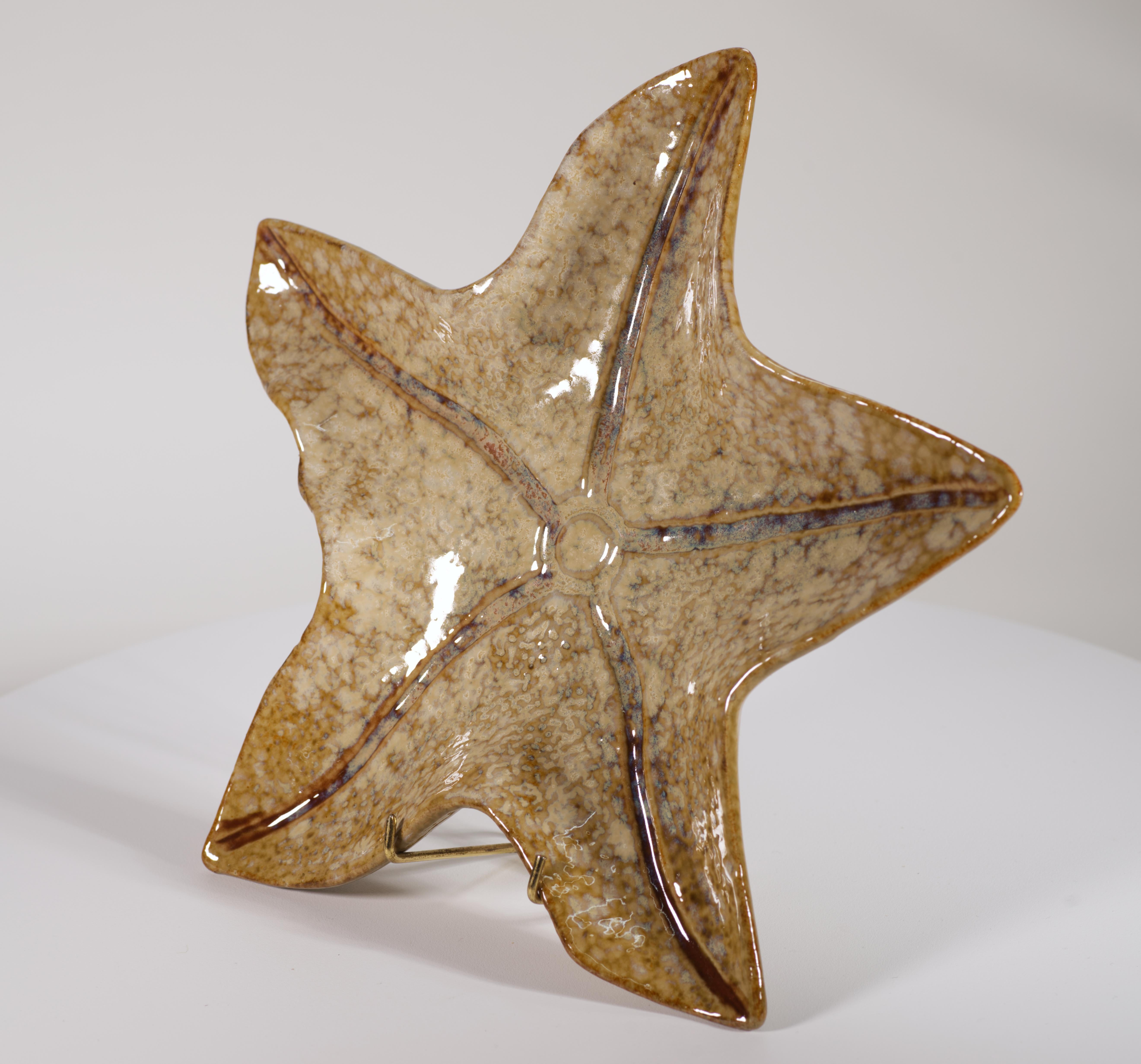  Ce petit plateau ou bougeoir Vintage Organic Modern présente une glaçure complexe blanc cassé, beige et marron clair. La forme de l'étoile de mer est accentuée par une texture légère et des lignes graphiques dentelées irradiant à partir du centre.
