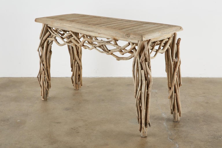 California coastal driftwood branch console table or sofa table made in the organic modern style. Constructed from a bleached teak wood frame with thick 2 inch planks and covered with beautifully weathered driftwood branches. Artison made with