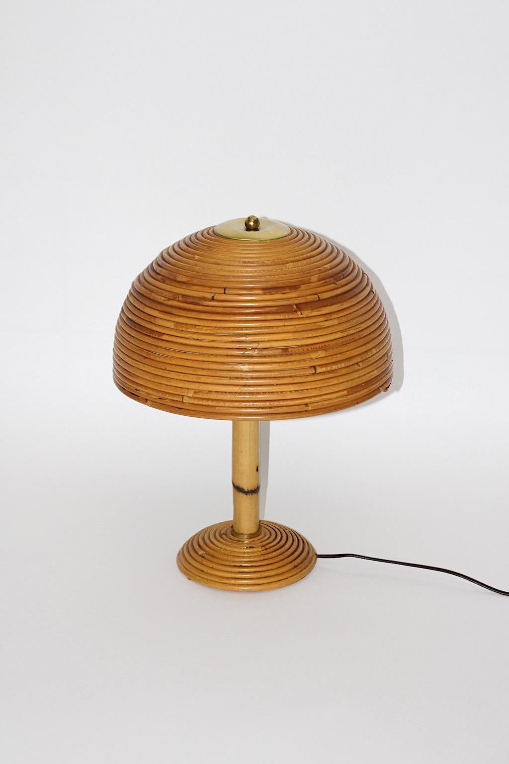 Organic modern vintage table lamp mushroom like from rattan and brass Italy, 1970s.
A beautiful lamp shade mushroom like shows rattan work and brass details, the stem from bamboo features lively play from structure.
One E 27 socket and on / off