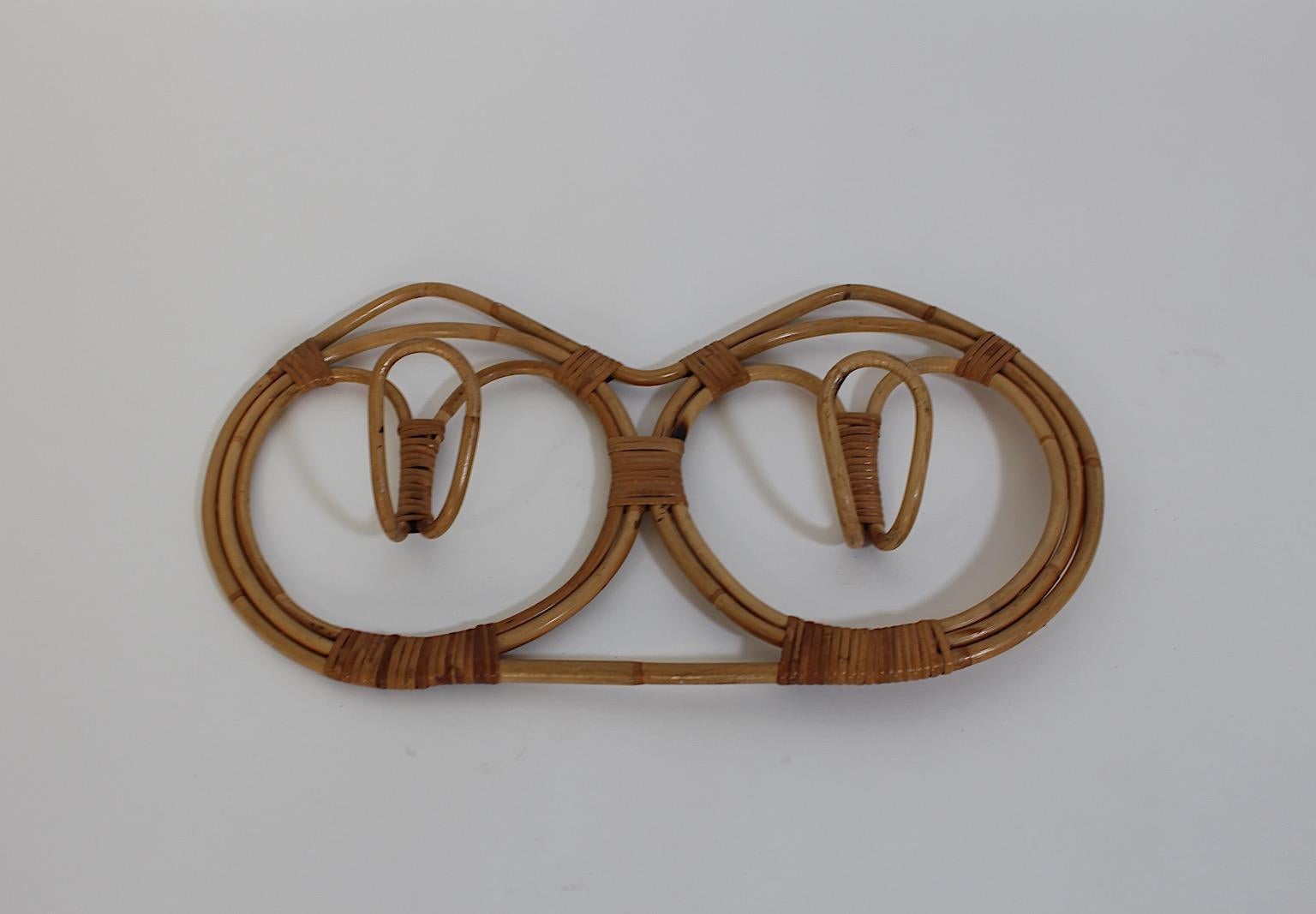 Organic  vintage Cloth Hanger from bamboo rattan design attributed to Franco Albini and Franca Helg 1961 Italy.
A wonderfully organic coat hook from bamboo rattan with two hooks in a gently curved shape.
This round form with nicely wrapped rattan