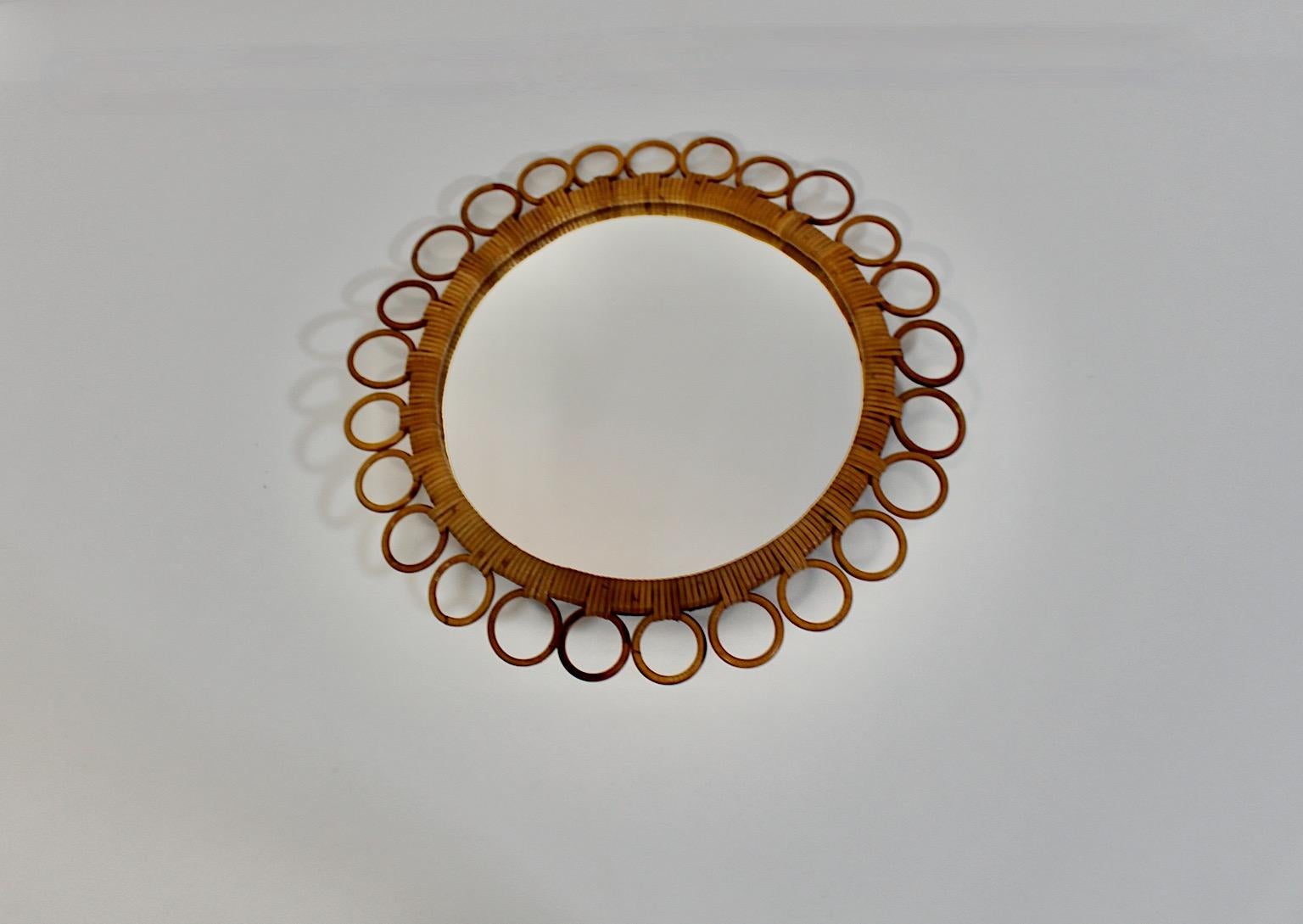 Organic Modern vintage circular wall mirror from rattan and mirror 1950s Italy.
A charming vintage wall mirror in circular shape from rattan with loop decor showing a wonderful size.
This stunning  wall mirror features a rattan wrapped frame with