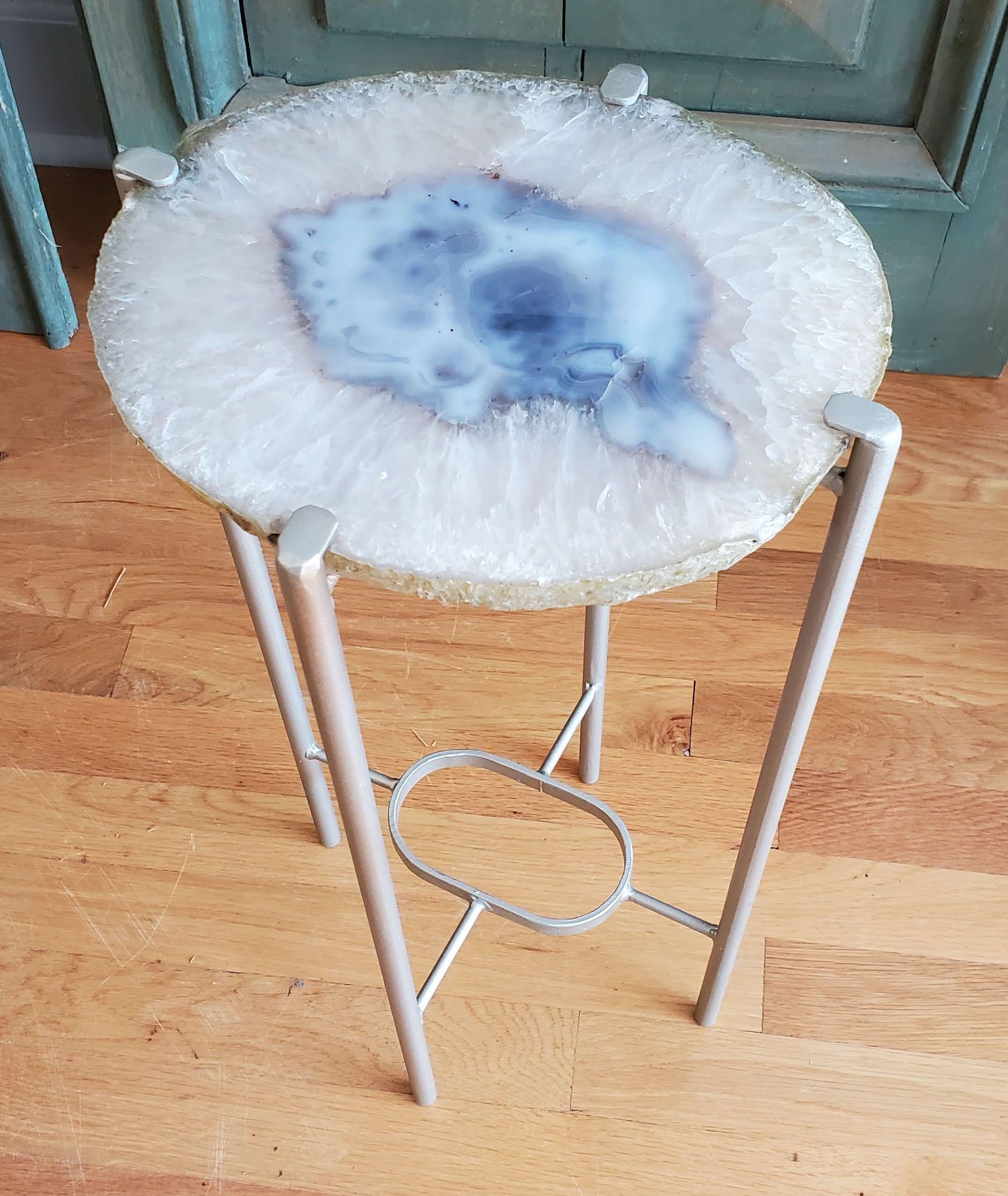 Our gorgeous geode drinks table is a perfect addition to any sitting room especially in an area where the sun hits them just right. Handcrafted with one of a kind geode slabs and nickel gilt metal. this table is available as pictured or can be