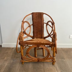 Sillón modernista de líneas orgánicas, de ratán y piel de vaca, fabricado en Italia, década de los 60
