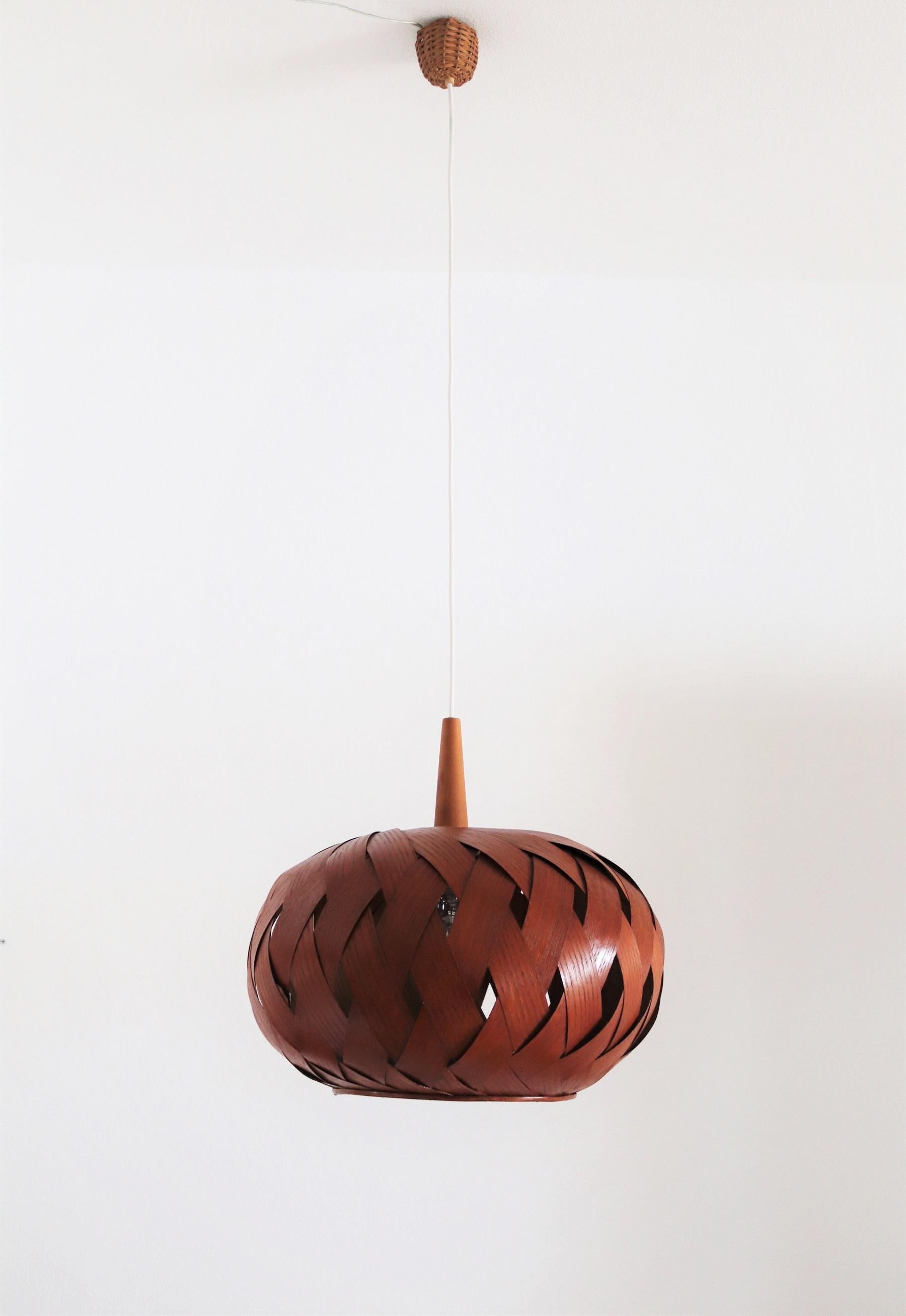 12 pcs. available.
Gorgeous modern pendant lamp in organic, natural shape made of teak wood veneer or bentwood, teak details and wicker in the middle of the 20th Century.
The pendant is hand crafted and in good to excellent condition.
The