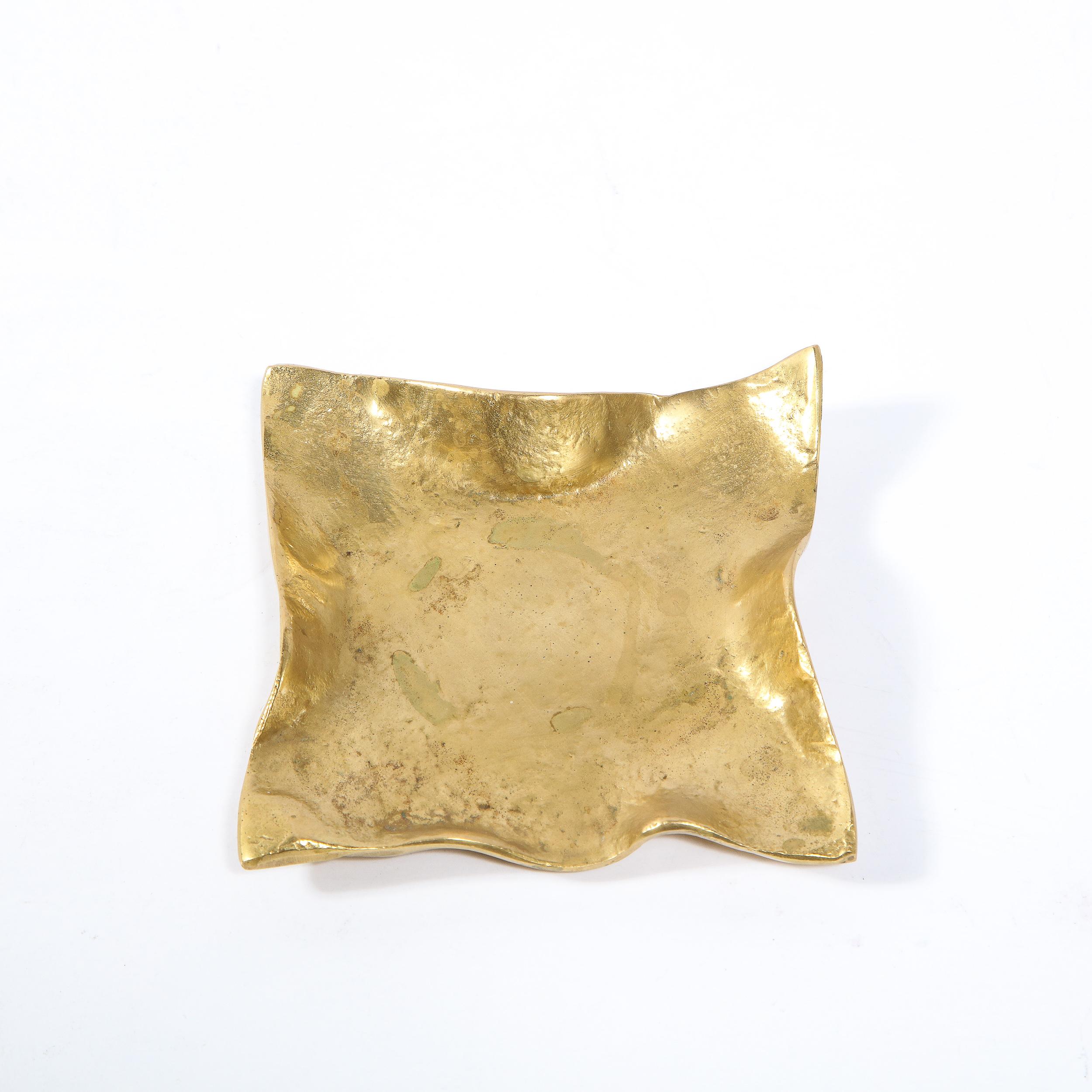This elegant and sophisticated decorative dish was realized in the United States during the latter half of the 20th century. It features a ruffled square form in polished brass that suggests both a pocket square and a napkin. Cleverly, the piece is