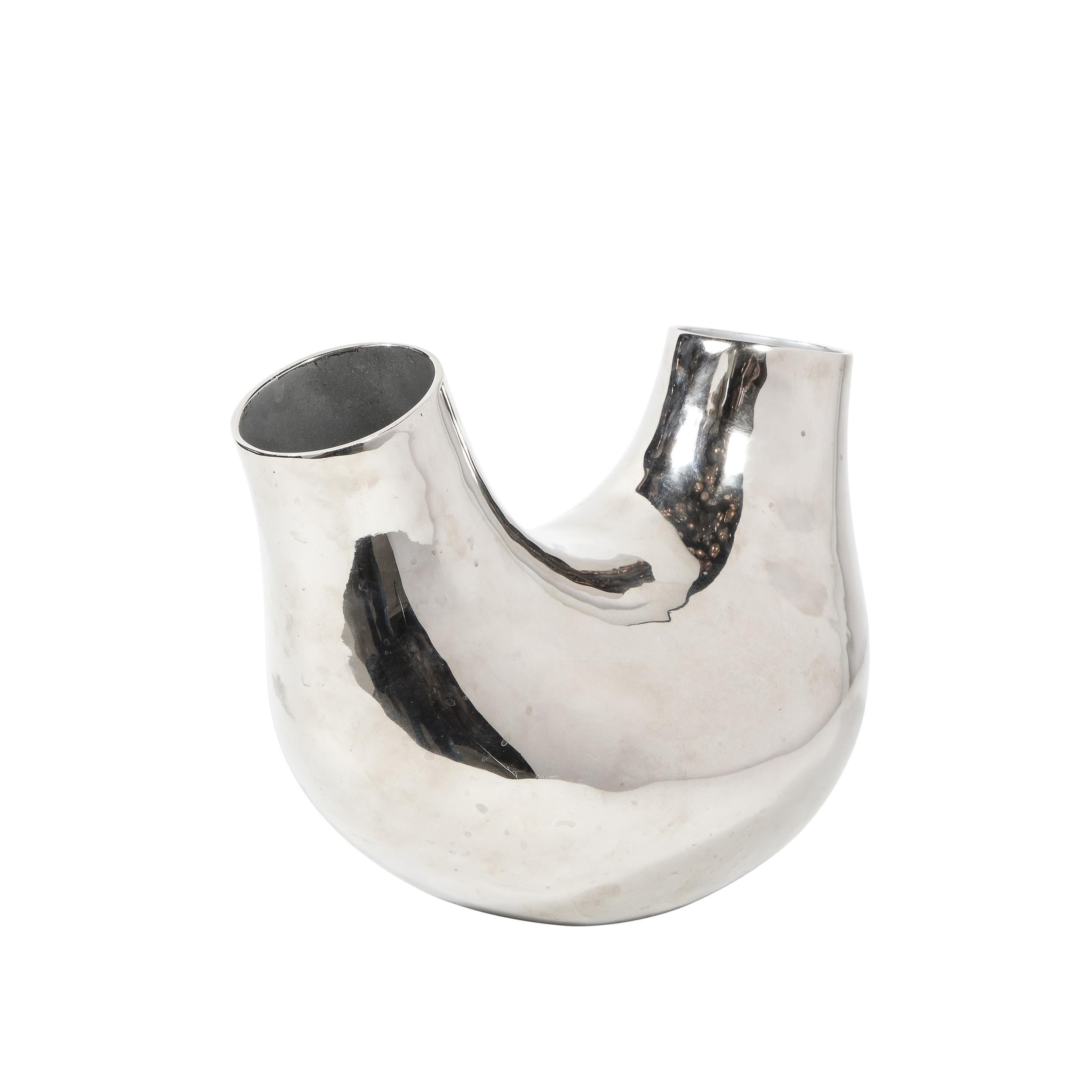 This stunning and graphic modernist vase was realized by the esteemed designer Christian Tortu. It features a stylized-U form with two circular openings, slightly staggered in height, at each end. Organic, full of sinuous curves and realized in a