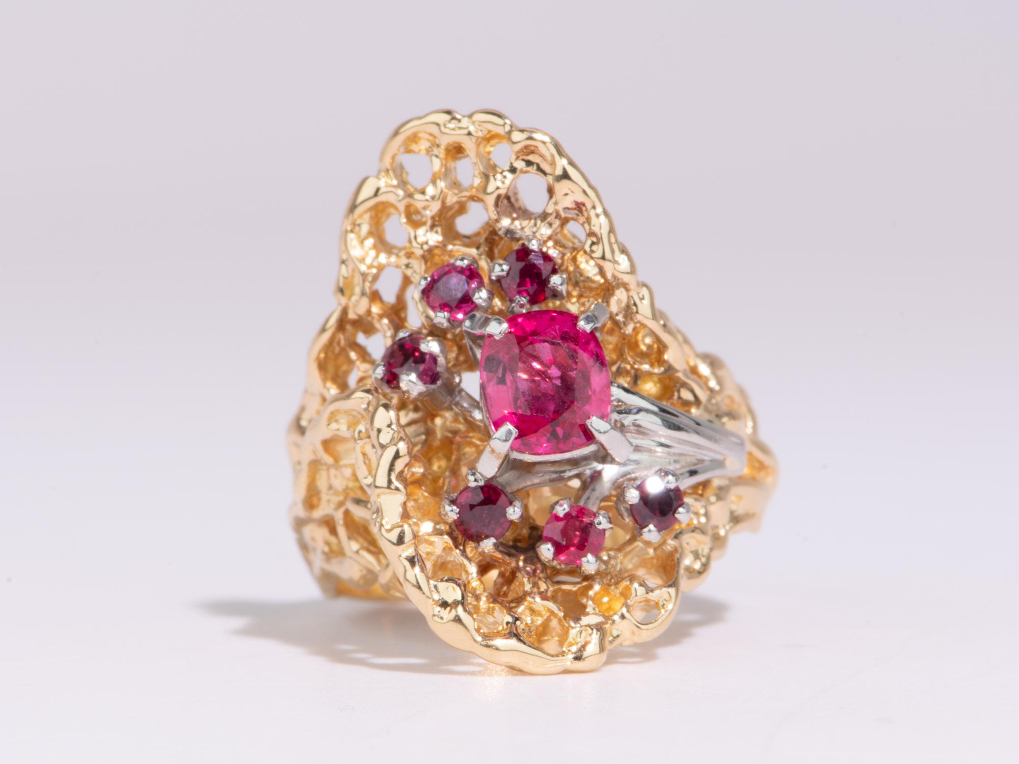 Zeigen Sie Ihren einzigartigen Stil mit diesem Statement-Ring! Mit seinem organischen Design und den leuchtend roten und rosafarbenen Edelsteinen ist dieses einzigartige Stück ein echter Hingucker. Glänzen Sie im Rampenlicht mit diesem exquisiten