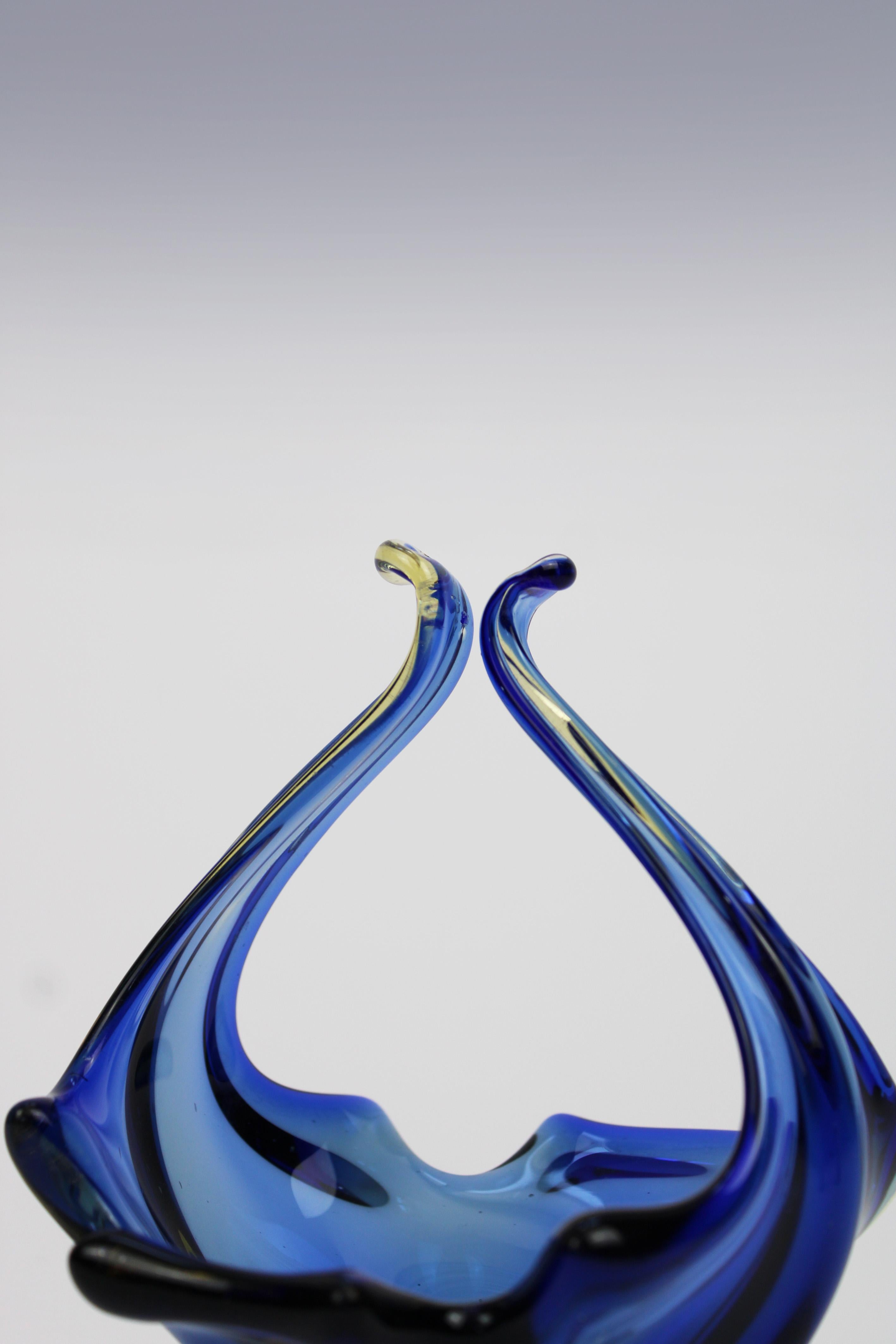 Wir stellen eine atemberaubende organische Murano-Schale vor, ein schönes Beispiel italienischer Glaskunst aus dem 20. Jahrhundert. Diese exquisite Schale zeigt ein bezauberndes Blumendesign in leuchtenden Blau- und Gelbtönen, das die