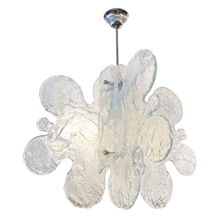 Murano glass pendant made by Mazzega in the 1960s featuring four organically shaped and textured glass slabs joined by a central frame. When the light is off, the glass has a light blue tint and when turned on it has some hints of yellow. Nickel
