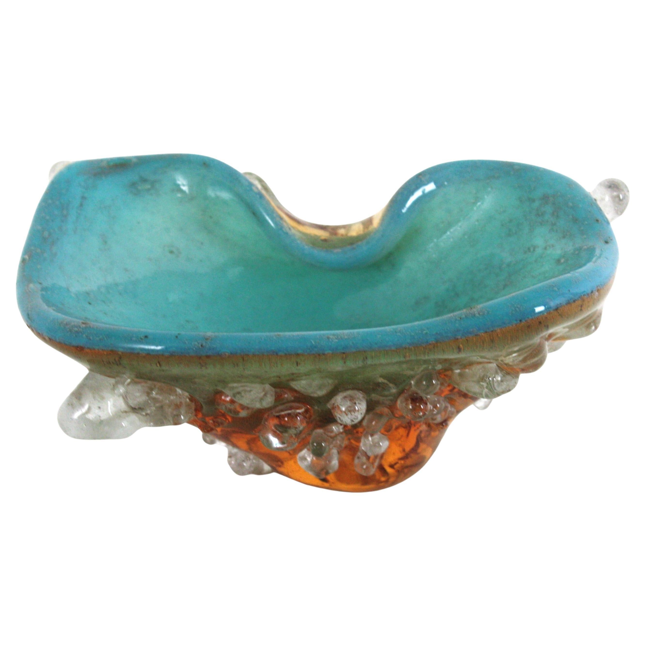 Cuenco de cristal de Murano de forma libre, único en su género, de color azul turquesa y ámbar, con gotas de cristal transparente aplicadas por Murrine. 
Italia, años