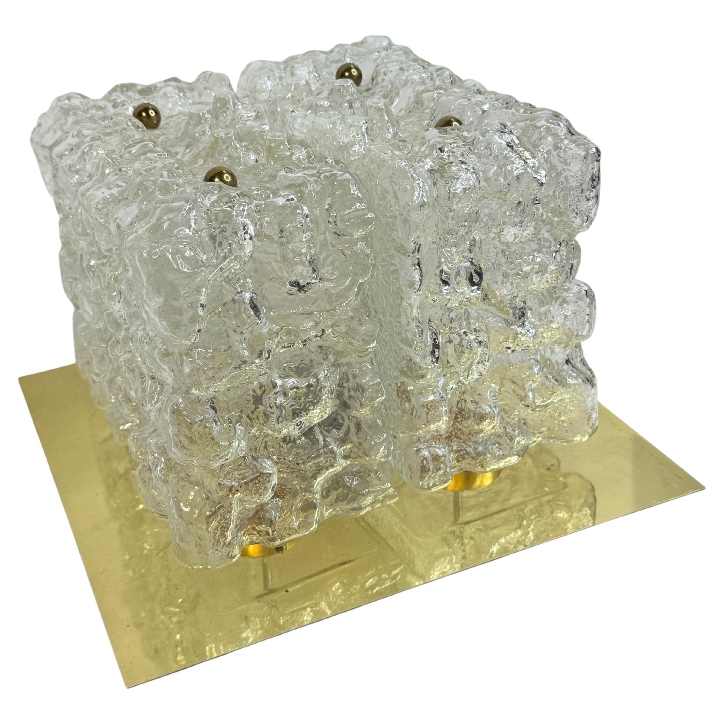 Precioso aplique Limburg 1970, Alemania cuatro cristales individuales con una textura orgánica burbujeante cada cristal descansa sobre un remate redondo de latón una bombilla Edison en el centro oculta por el cristal el marco es una placa de latón