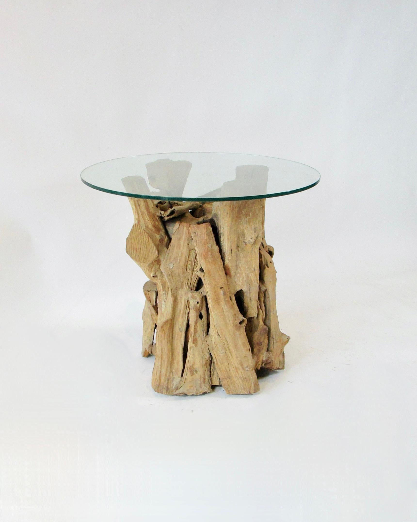 Base de mesa moderna orgánica . ensamblada con piezas brutas de madera encontrada, algunas talladas en astillas  . La tapa redonda de cristal se asienta sobre una base de 24