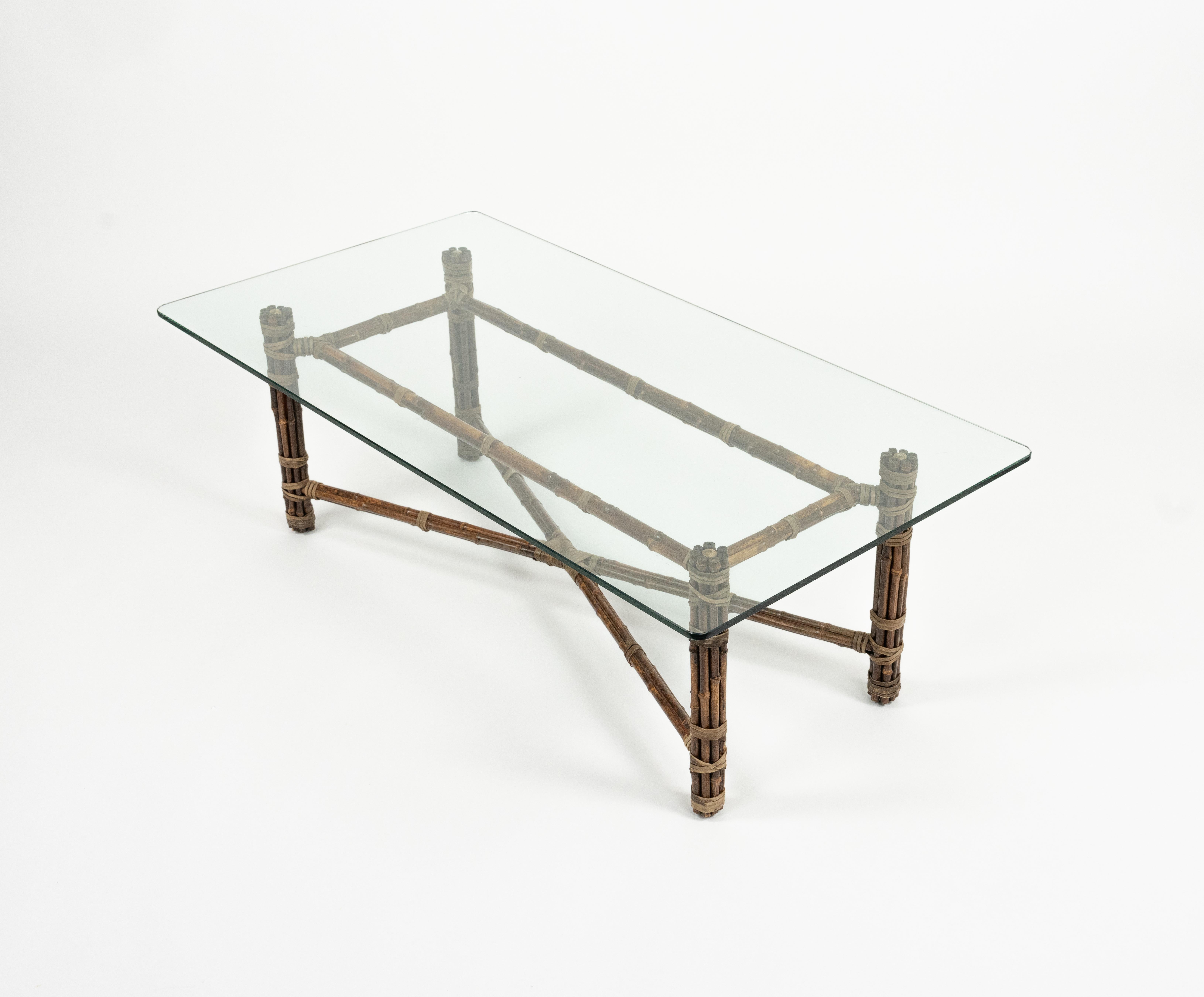 Table basse rectangulaire à quatre pieds, de forme organique, conçue par John McGuire.

Cette table basse, entièrement fabriquée à la main, est composée de tuyaux de fer, de tiges de bambou et de laçage en cuir brut, avec un plateau en verre.

Les