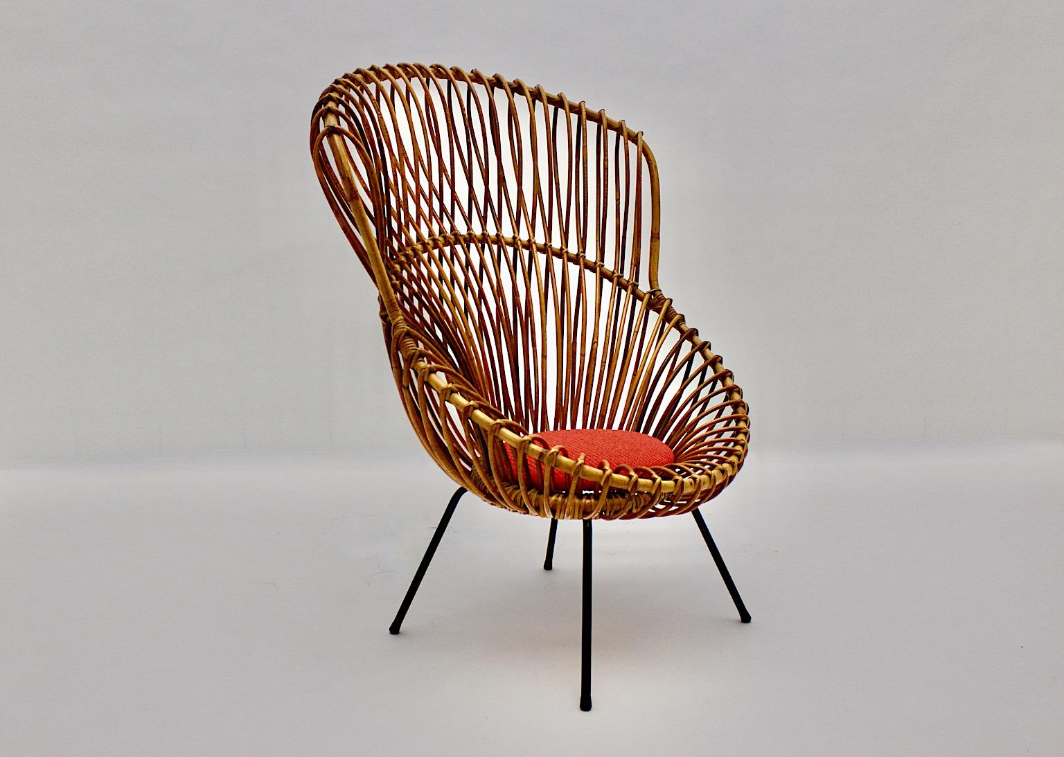 Mid-Century Modern vintage riviera style organic lounge chair or side chair from woven rattan and metal attributed to the design by Franco Albini 1950s Italy.
While the seat shell shows a beautiful woven rattan work the feet from black lacquered