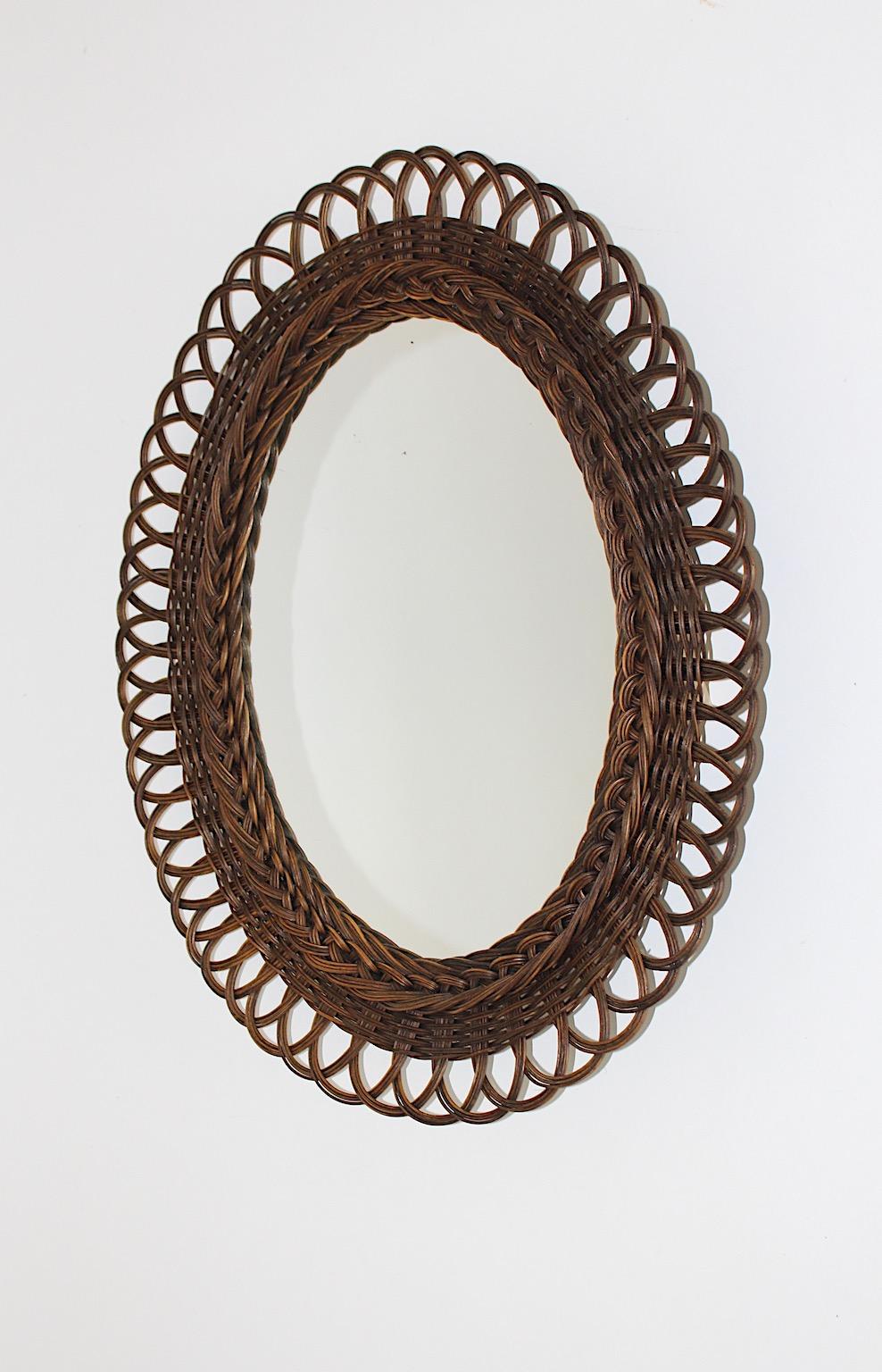 Organic Miroir mural rustique vintage de forme A avec cadre en saule tressé marron années 1970 Autriche.
Une belle nouveauté organique, ce miroir mural de forme ovale avec un cadre tressé brun chocolat en saule avec de merveilleuses tresses et