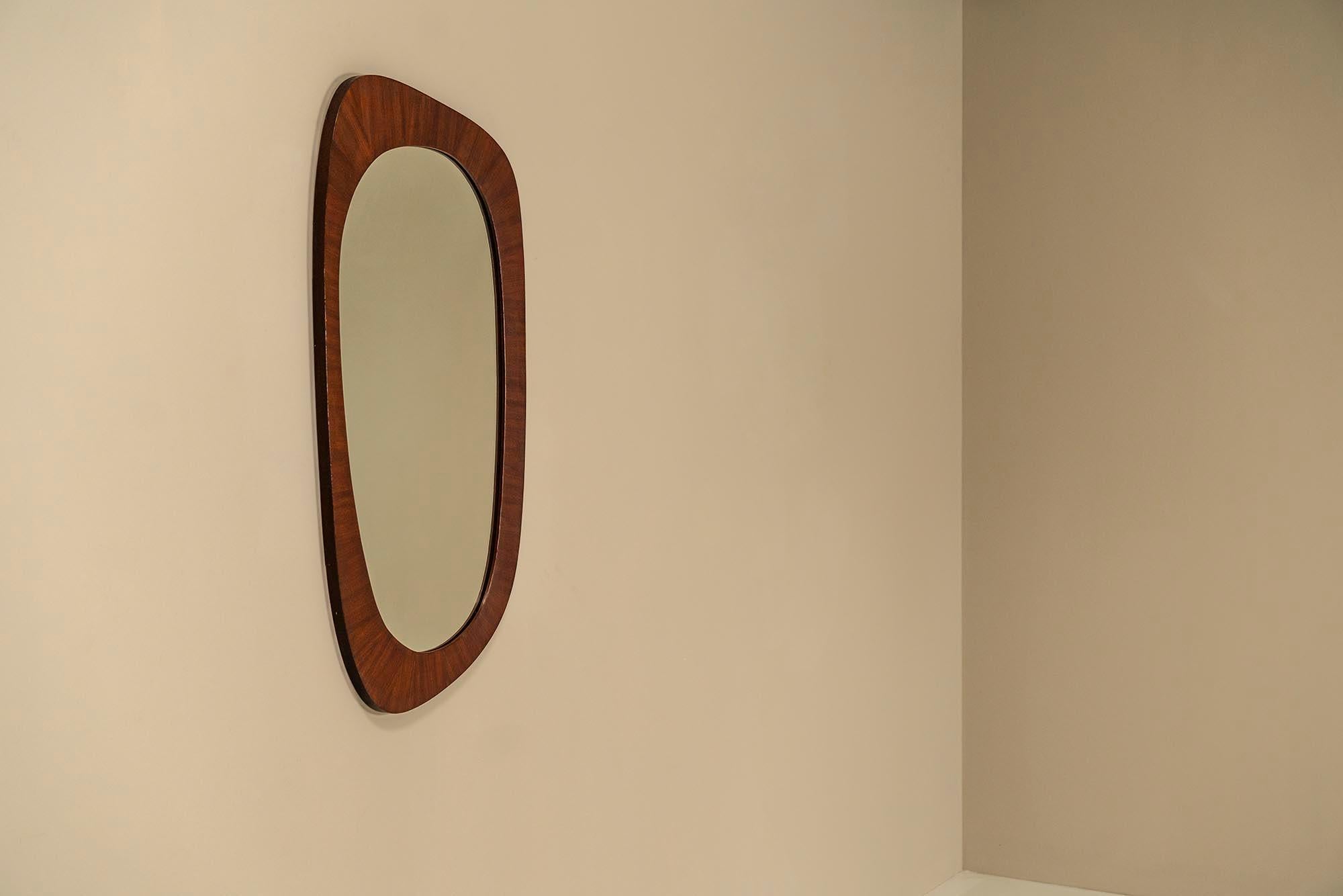 Organic shaped mirror in teak.In addition to its function, this well-formed mirror from the 1970s has a high decorative value. It has a groovy design and makes up for a wonderful object to decorate the room.The organic or asymmetrical shape has a
