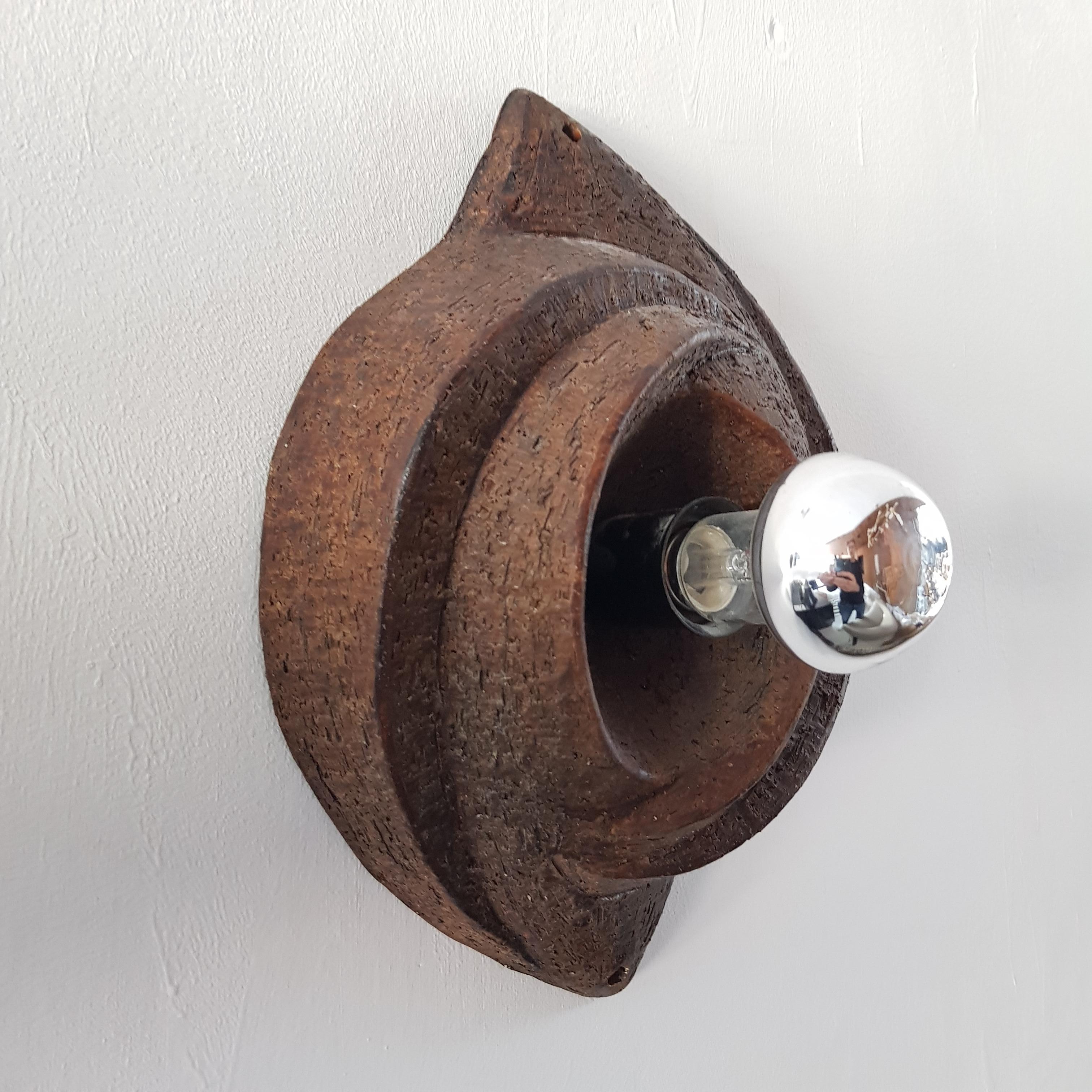 Robust vintage ceramic wall lamp from seventies. A real eye-catcher in a brutalist interior. The lamp is designed in a raw organic shape and is made in hand moulded earthenware/ceramics. The lamp comes complete with a ball lamps with silver mirror