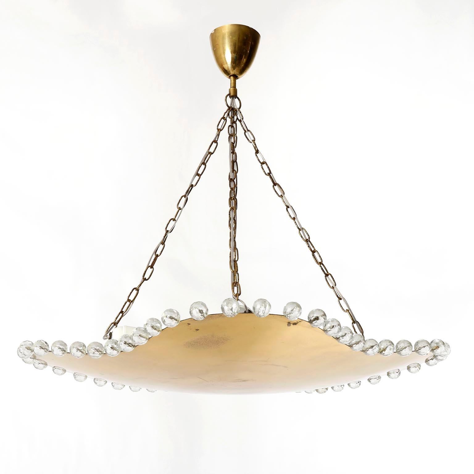A gorgeous uplight chandelier by Rupert Nikoll, Vienna, Austria, manufactured in Mid-Century, circa 1960 (1950s or early 1960s).
An organic shaped brass bowl made of solid polished brass which has an aged surface in a rich and warm tone and lovely