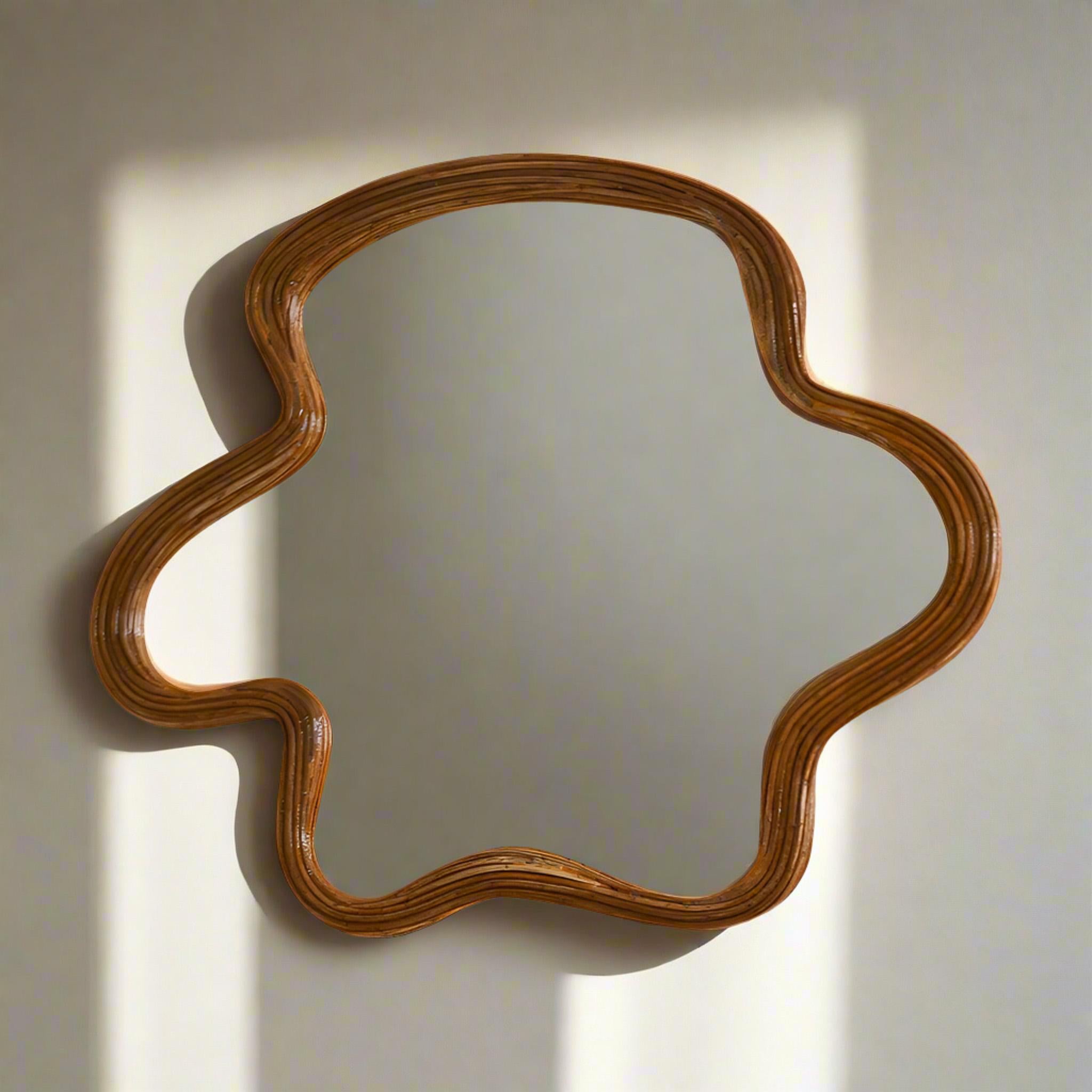 Fabriqué par des artisans qualifiés, ce miroir en rotin de forme organique ajoute une touche de beauté naturelle à n'importe quel mur. Fabriqué à partir de matériaux entièrement naturels, il ajoute non seulement une touche unique et délicate à votre