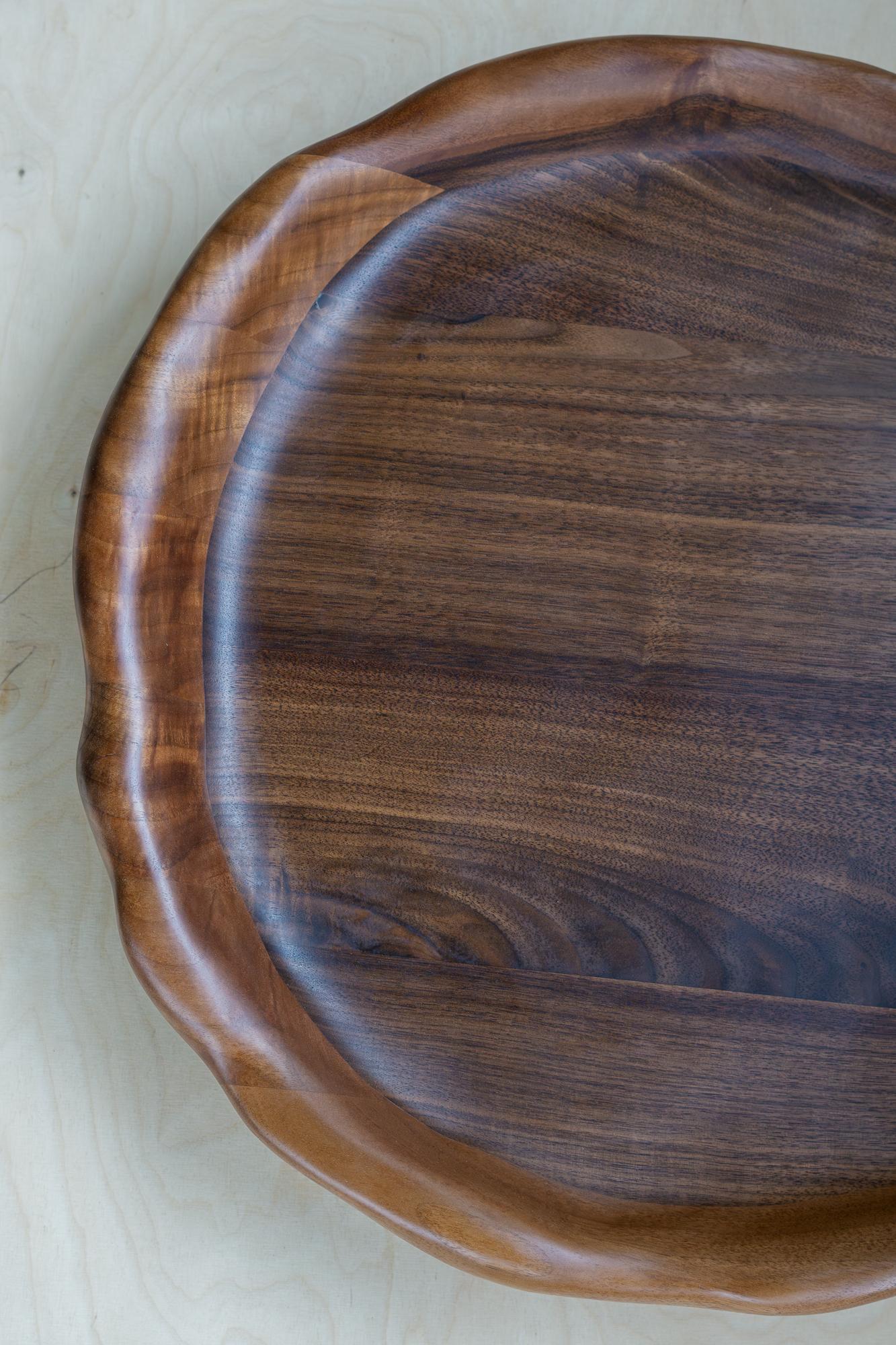 Il vassoio da portata viene modellato con vari strumenti a mano, rendendo ogni pezzo unico con le sue caratteristiche venature del legno. È realizzato in legno di noce di alta qualità e rifinito con un olio di cera dura sicuro per gli alimenti.

Il