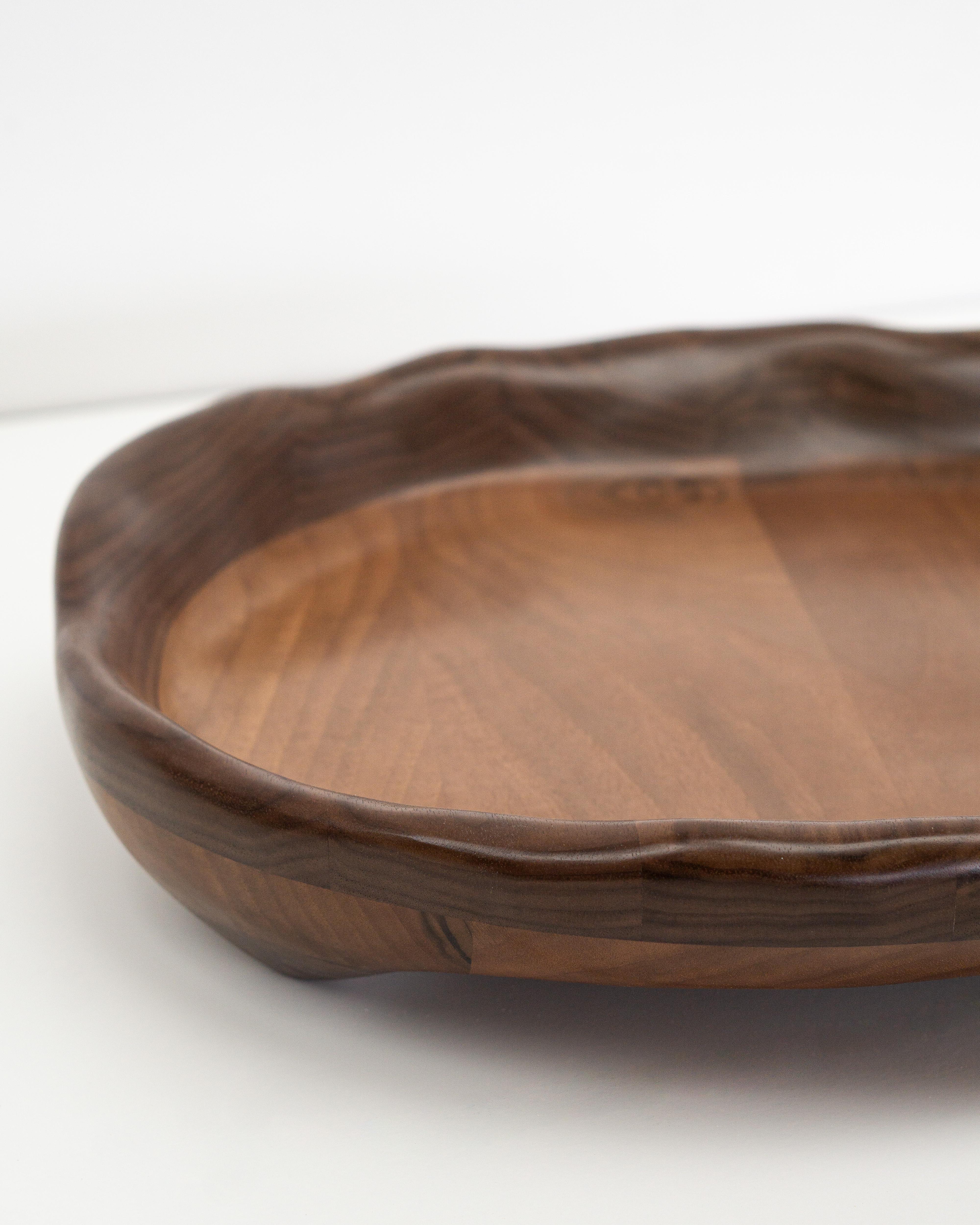 Il vassoio da portata viene modellato con vari strumenti a mano, rendendo ogni pezzo unico con le sue caratteristiche venature del legno. È realizzato in legno di noce di alta qualità e rifinito con un olio di cera dura sicuro per gli alimenti.

Il