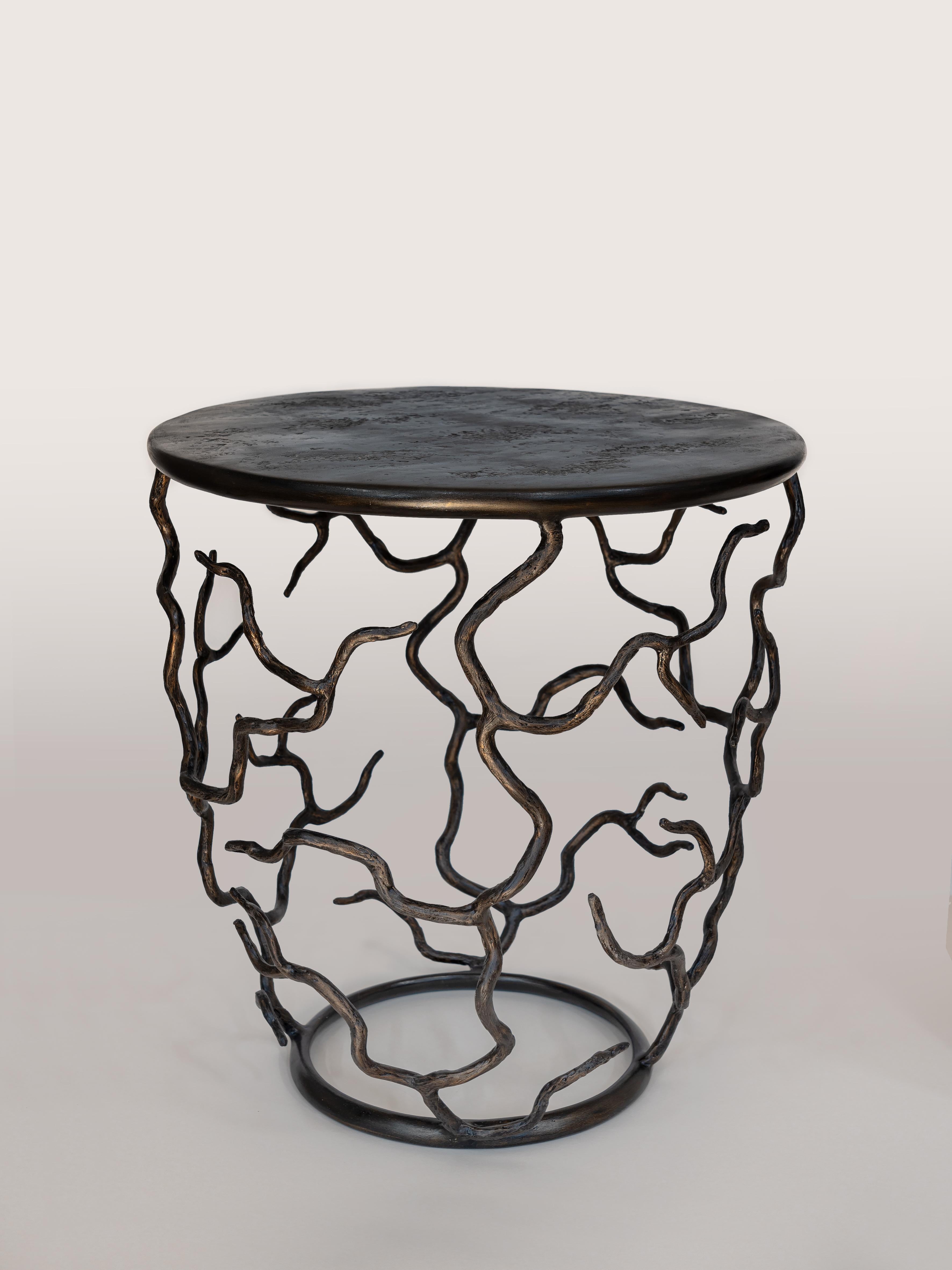 Organic forms and natural motifs. The Etna side table is individually hammered and hand formed. Each piece has been skillfully finished to resemble the texture of tree bark. The Top is hand-sculpted. Available in Antique Gold or Forest Brown Finish.